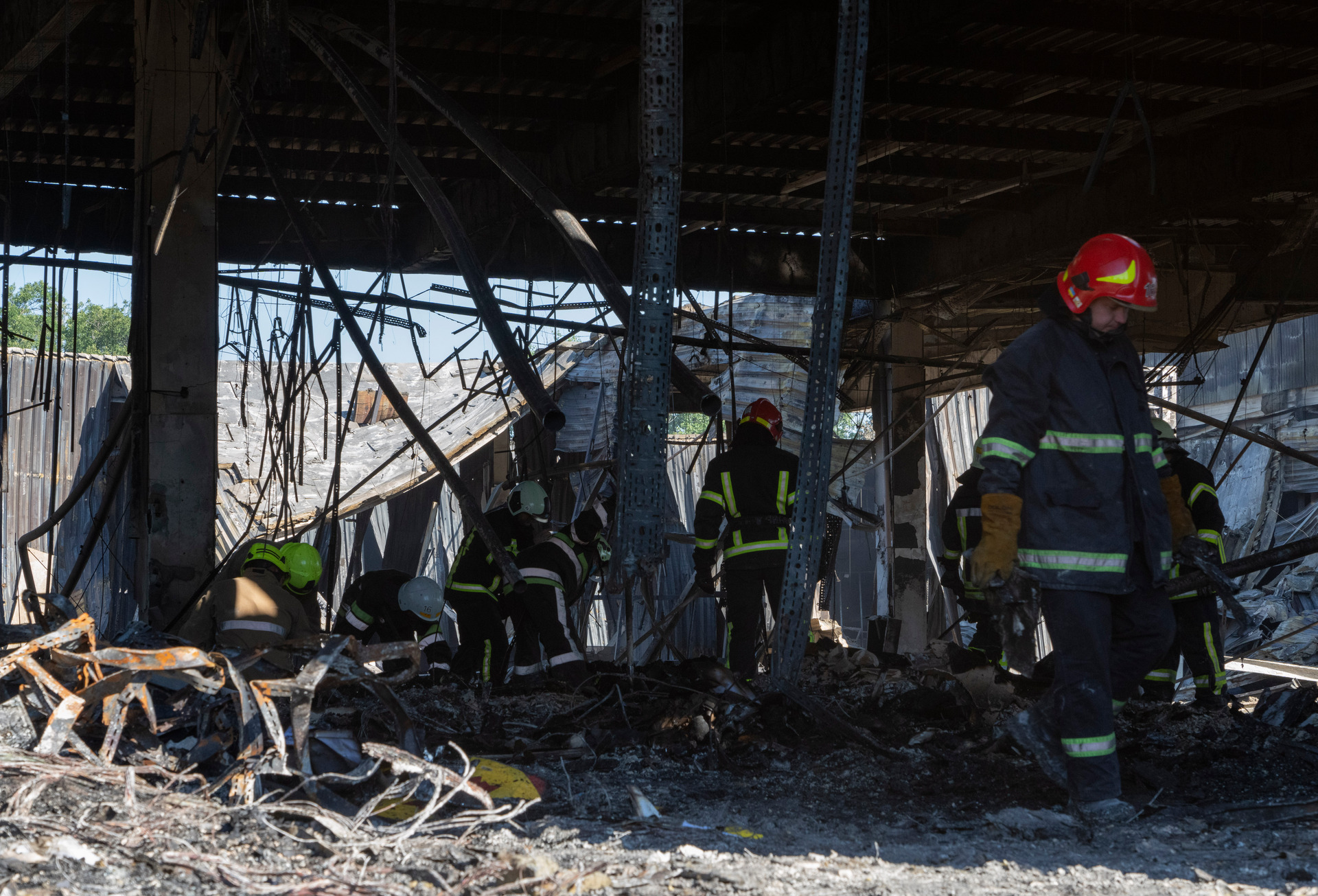 Ukrainian State Emergency Service firefighters clear debris at a shopping centreburned after a rocket attack in Kremenchuk. Photo / Efrem Lukatsky, AP
