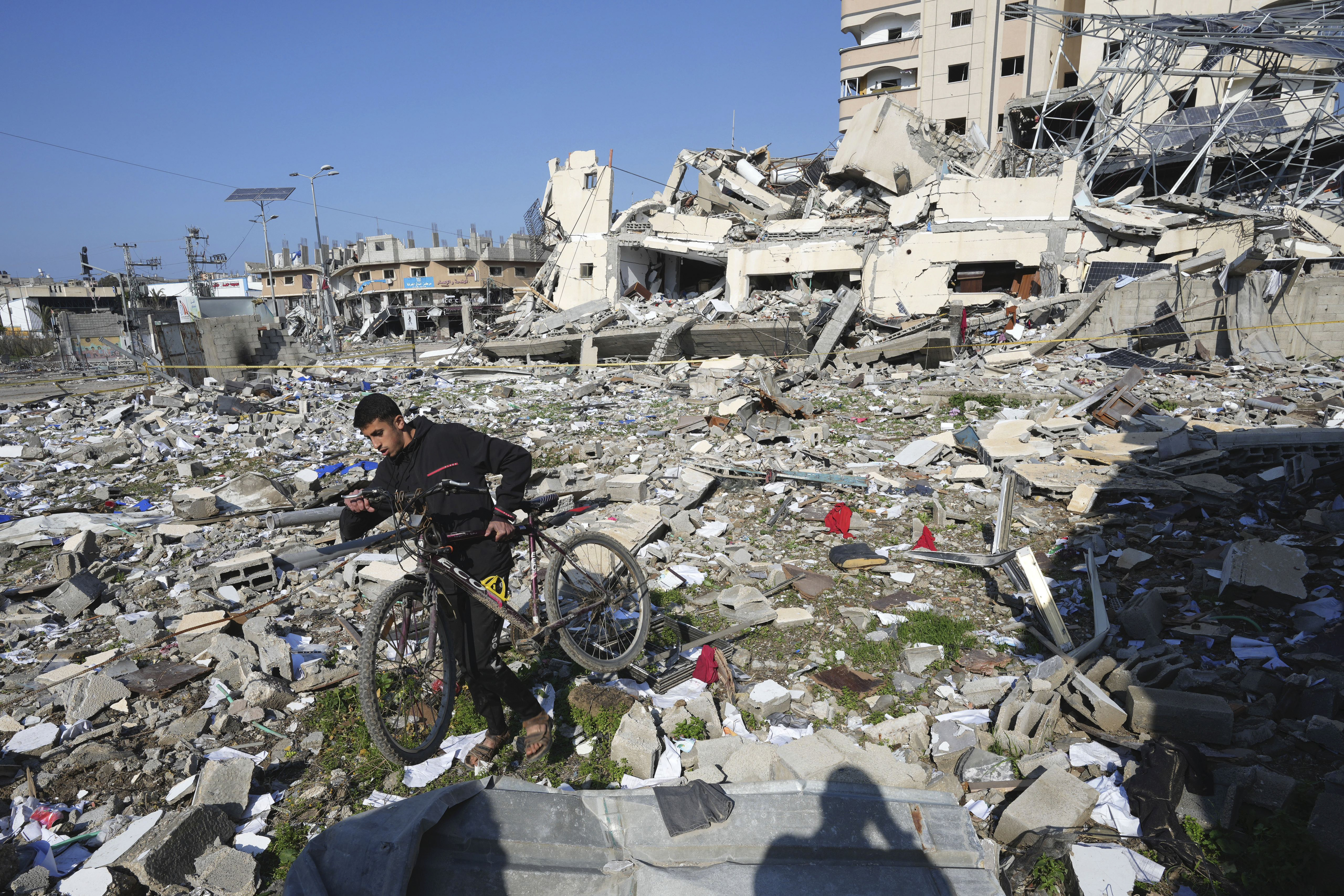 A Palestinian walks through the destruction by the Israeli bombardment in the Nusseirat refugee camp in Gaza Strip. Photo / AP 