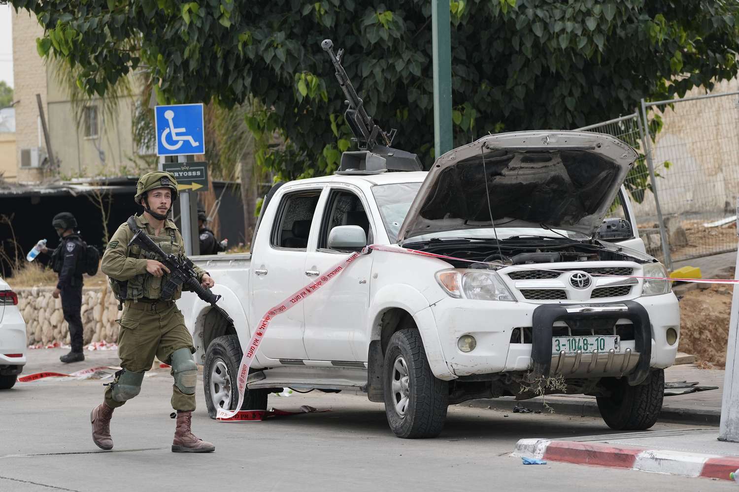 An Israeli soldier walks by a pickup truck used by Palestinian militants in the attacks on October 7, 2023, in Sderot, Israel.  Photo / AP