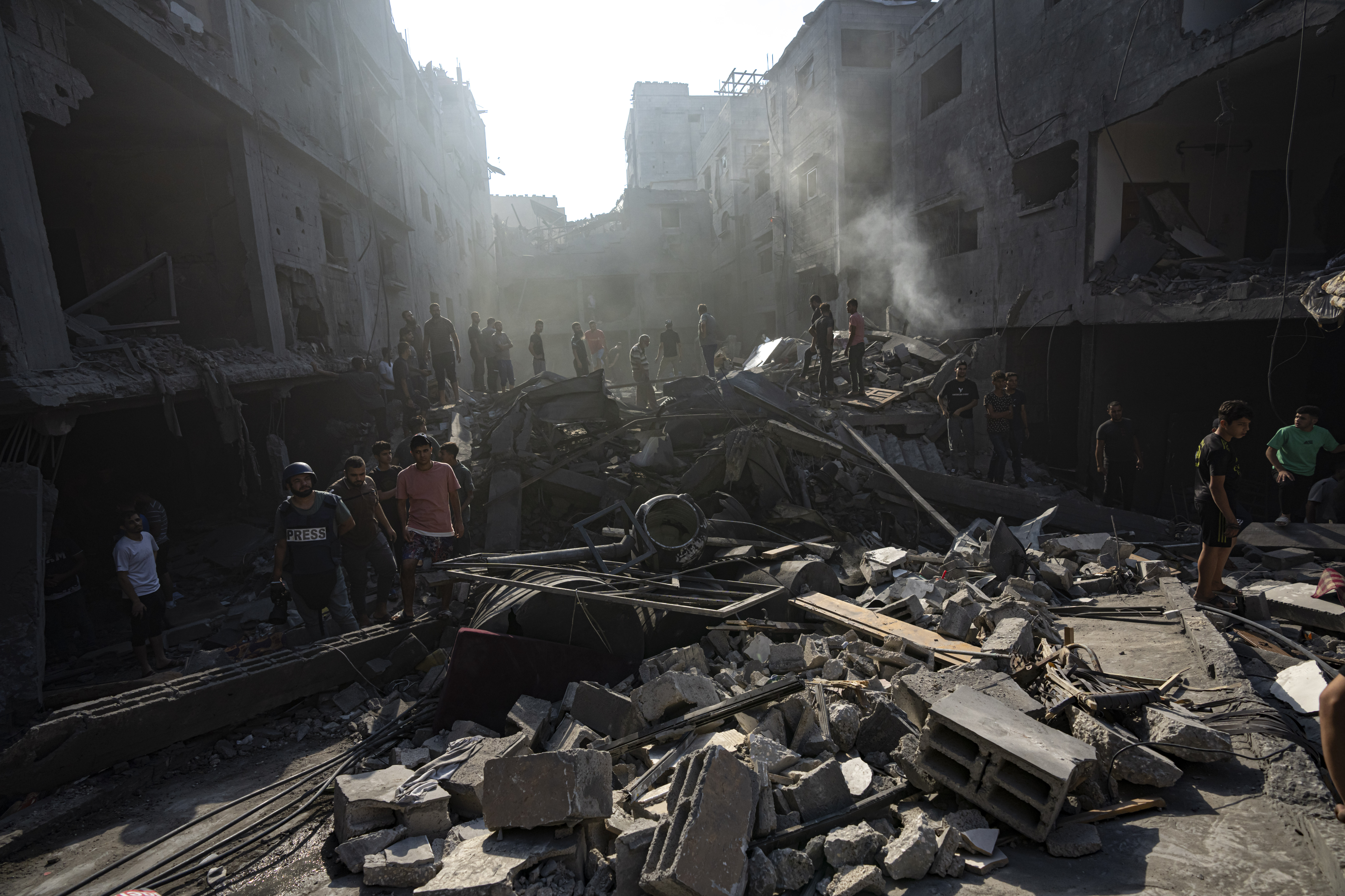 Palestinians search for bodies and survivors in the rubble of a residential building levelled in an Israeli airstrike. Photo / AP