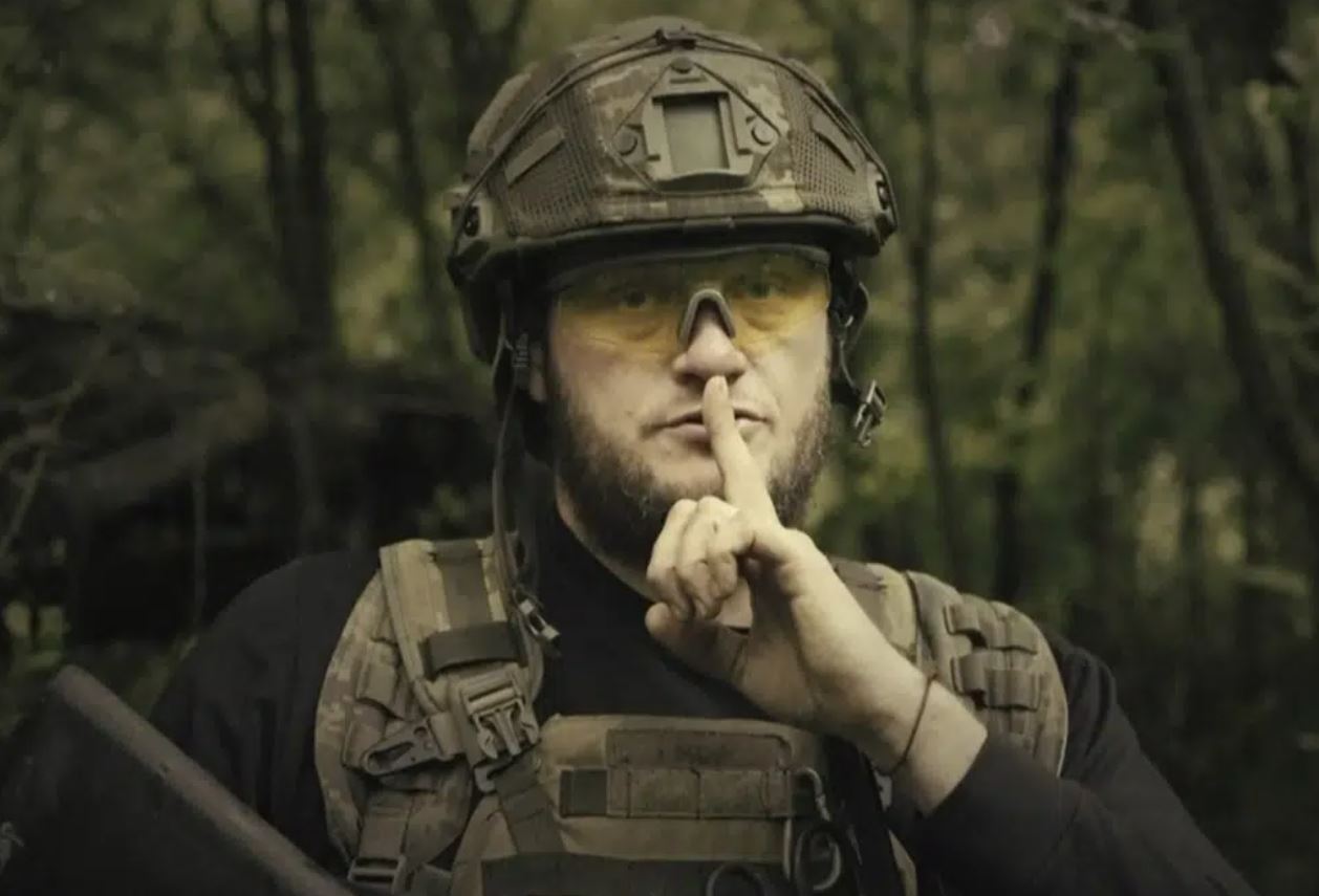 A Ukrainian soldier poses for the camera with his fingers to his lips, in an undisclosed location in Ukraine. Photo / AP