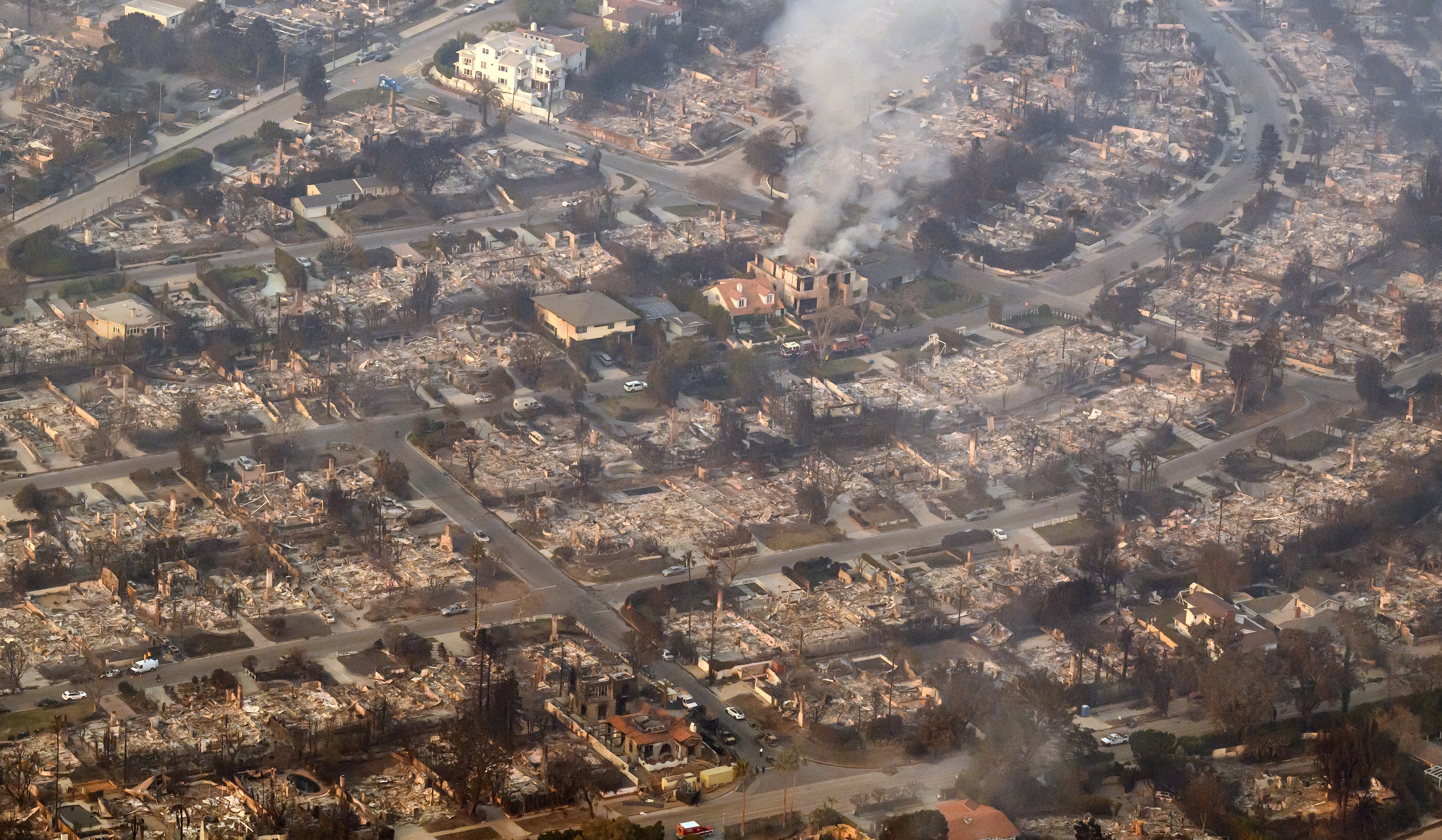 In this aerial view taken from a helicopter, homes burned in the Palisades fire smoulder near the Pacific Palisades neighbourhood. Photo / AFP
