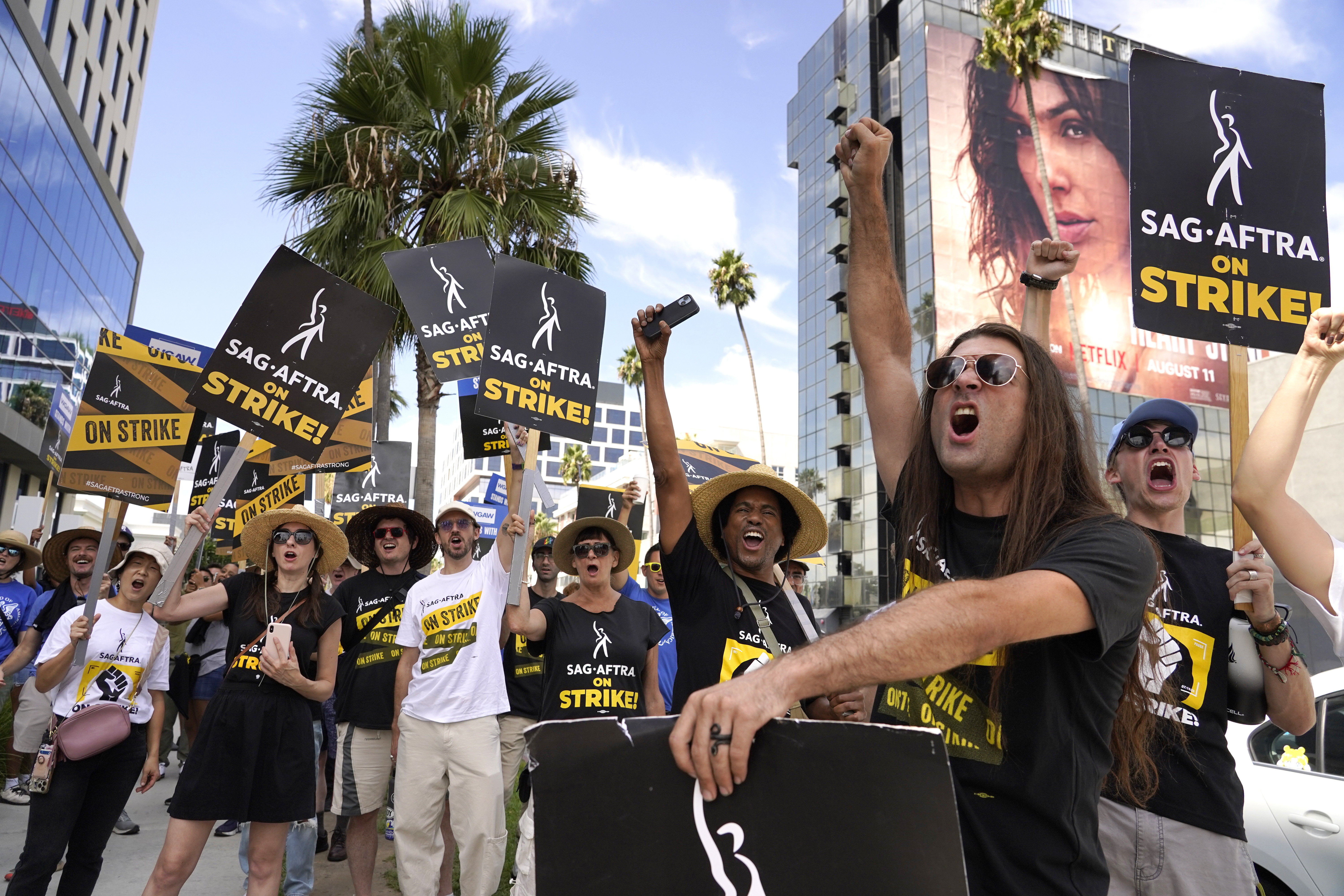Sag-Aftra member John Schmitt, second from right, and others carry signs on the picket line outside Netflix in Los Angeles. Photo / AP