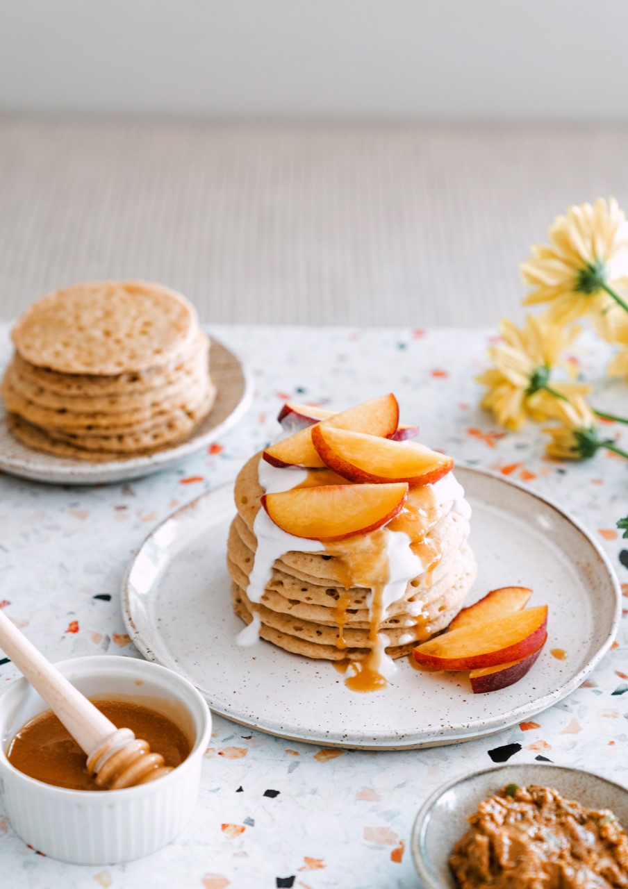 Kelsi Boocock savours traditional Moroccan baghrir crumpets with sweet nut butter, stone fruit, and honey at The Lunar Surf Hostel in Agadir.
