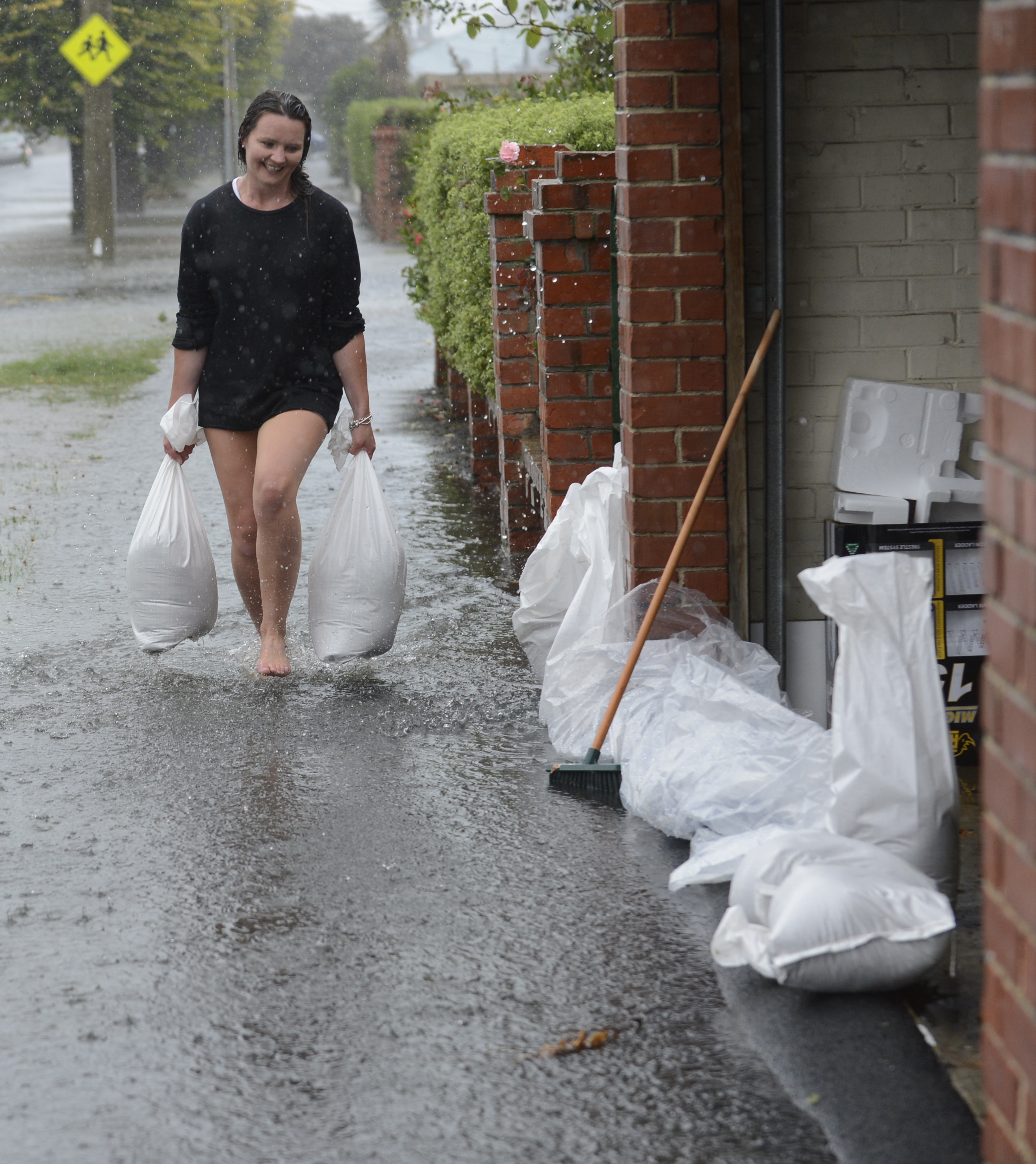 Shannon Goodwin helps sand bag her neighbour's property in Dunedin's Surrey St during flooding in February. Photo / File