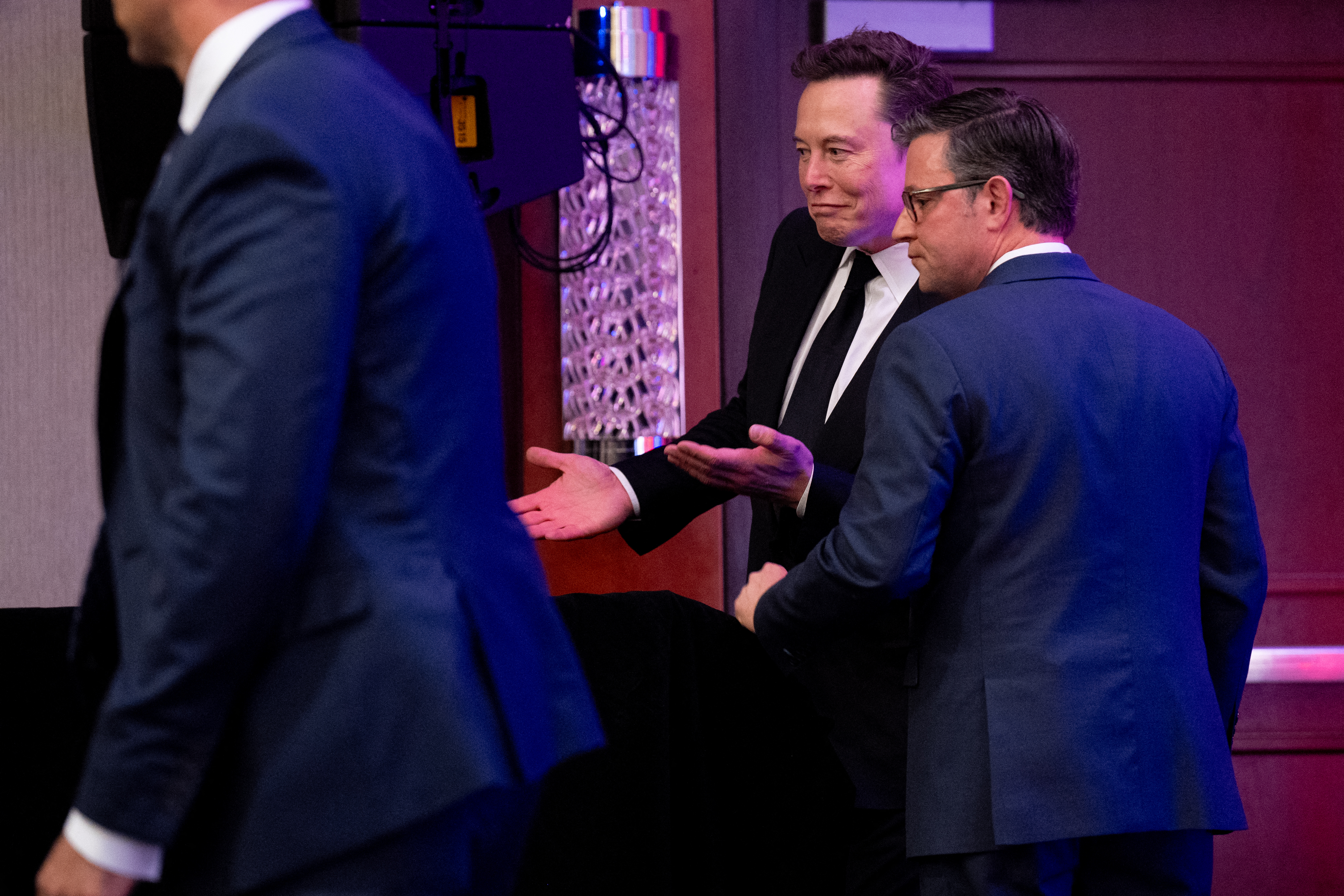 US Speaker of the House Mike Johnson tries to help Elon Musk to a seat as he arrives with President-elect Donald Trump to a House Republicans Conference meeting last week in Washington, DC. Photo / Getty Images