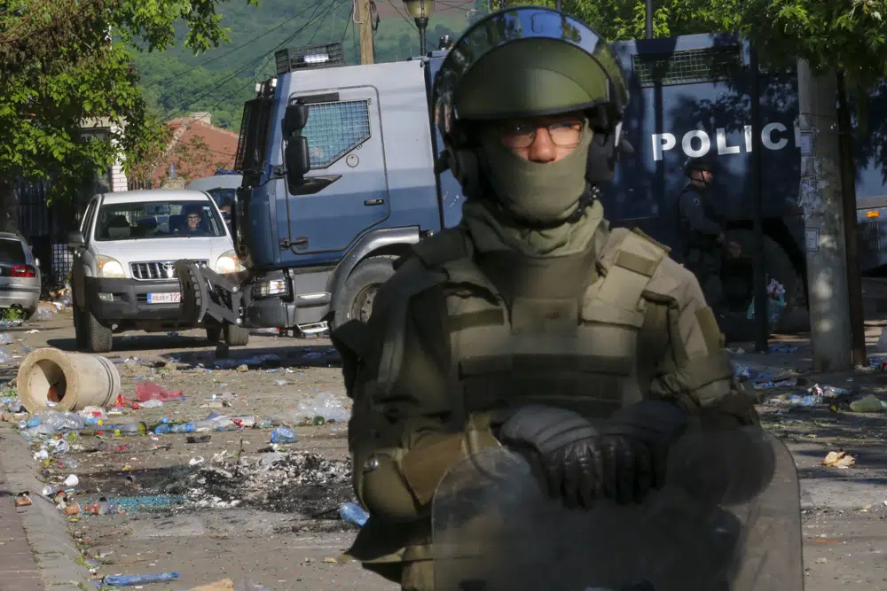 KFOR soldiers, front, and Kosovo police officers guard a municipal building. Photo / AP