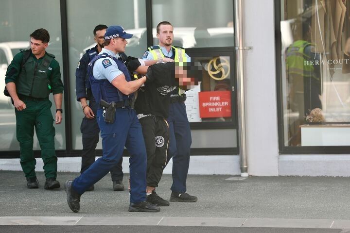 Police take a man into custody after a police chase across the city that ended in a crash on Karangahape Rd. Photo / Dean Purcell