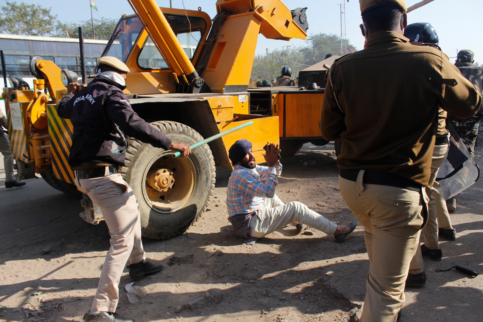A farmer desperately pleads with policemen as they beat him during a protest at the border between Delhi and Haryana state. Photo / AP