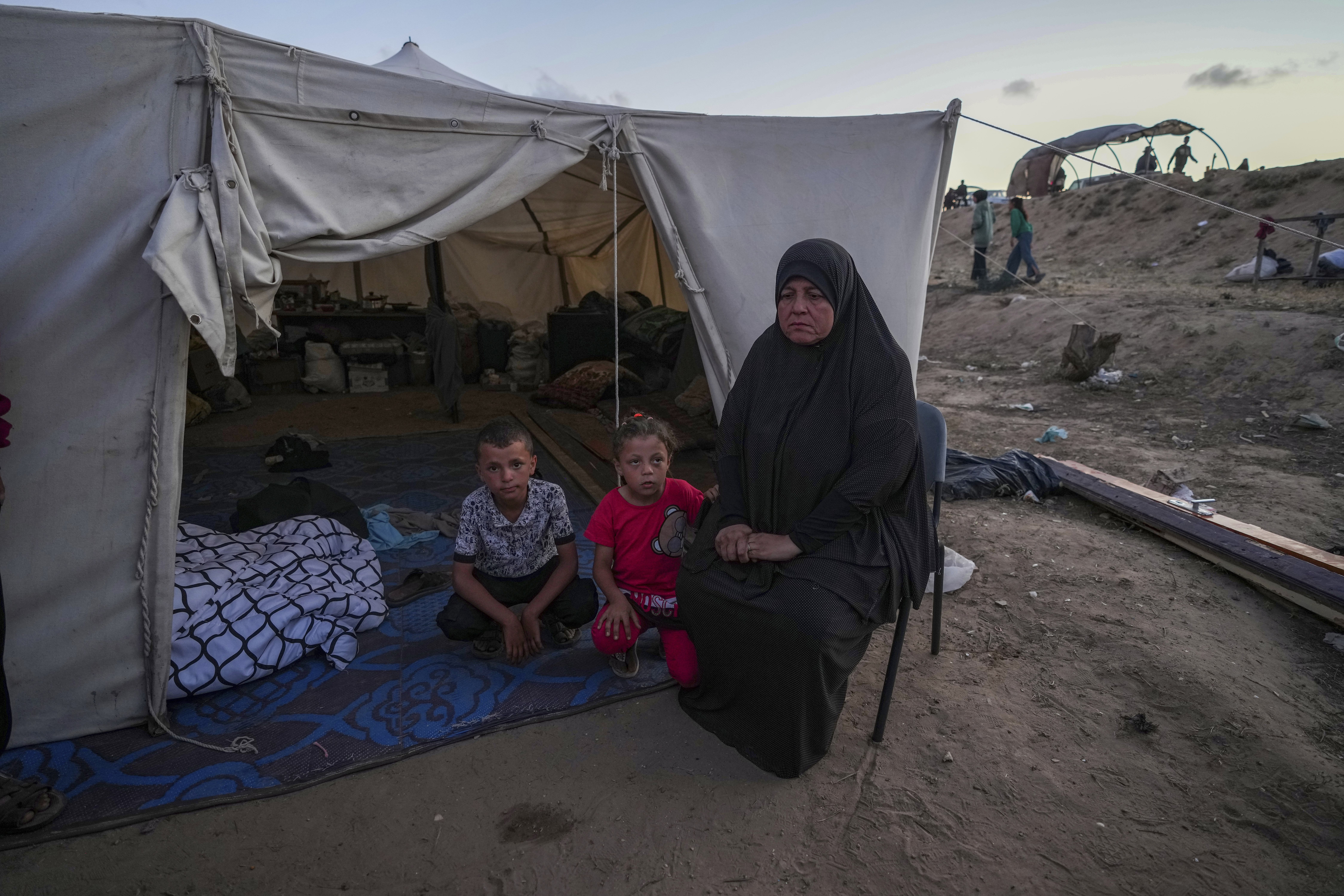 A Palestinian woman sits in front of her makeshift tent with her grandchildren after been displaced by the Israeli air and ground offensive on the Gaza Strip. Photo / AP