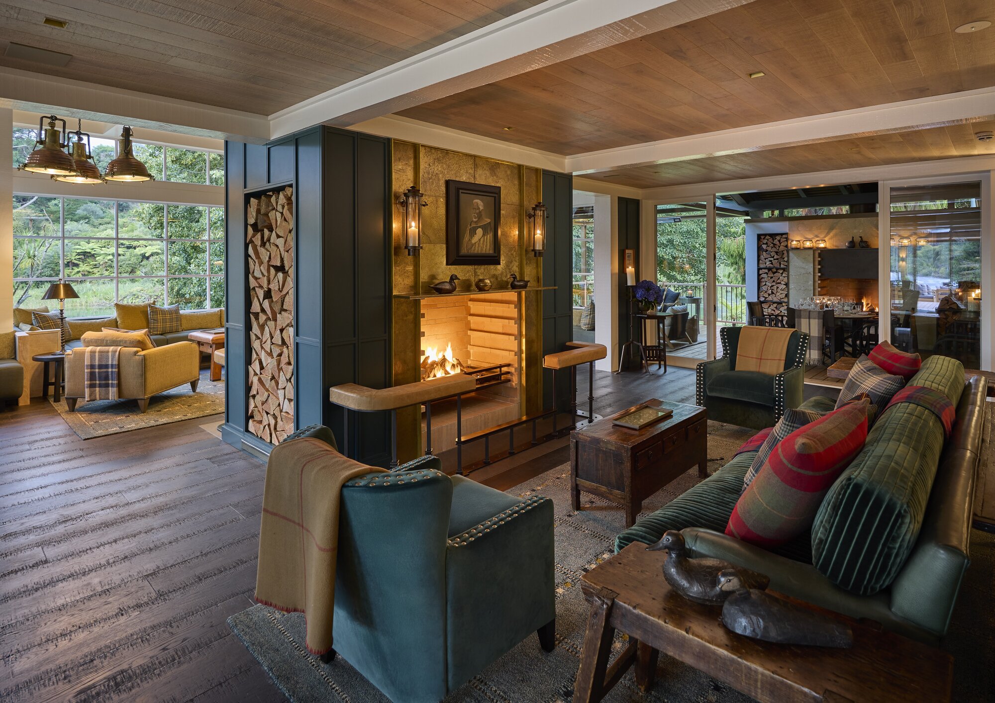 The centrepiece of the River Room is the double-sided fireplace, above which hangs Te Hau Takiri Wharepapa by Philip Holmes. The green couch is a long-time guest favourite and has been refurbished. Photo / George Apostolidis