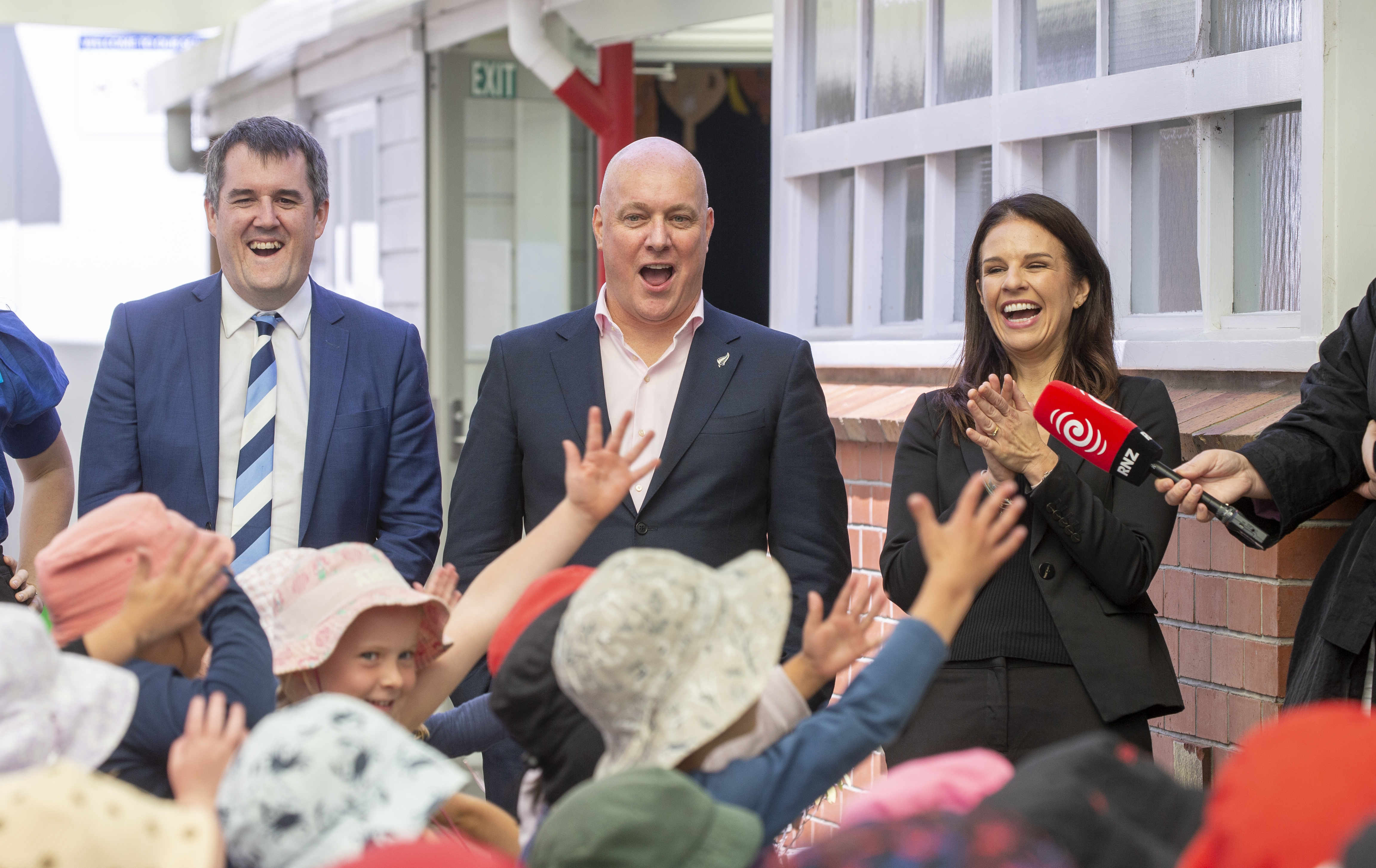 National's Chris Bishop (left), Christopher Luxon and Erica Stanford react to Silverstream School doing some Jump Jam dancing. Photo / Mark Mitchell