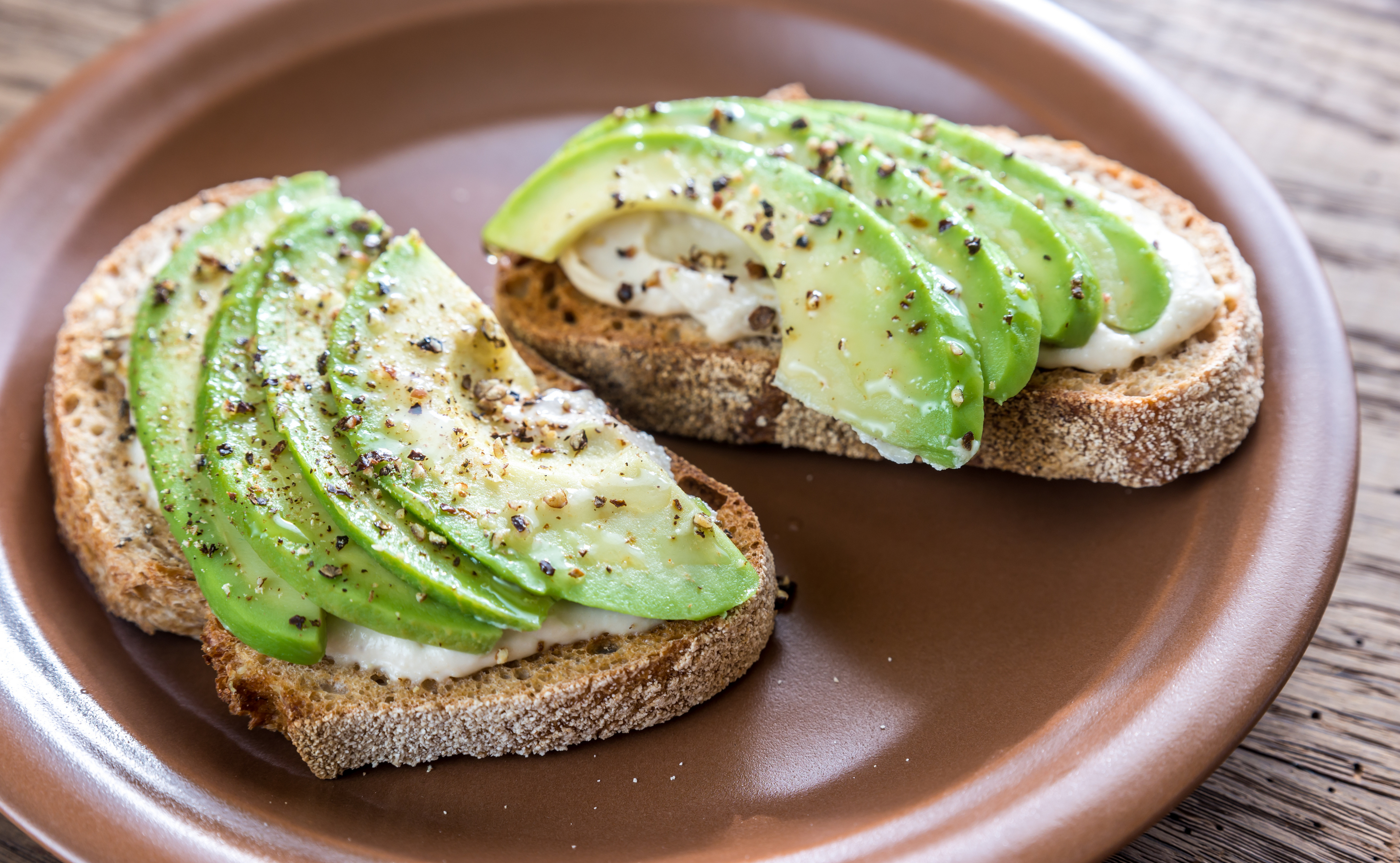 Toast with tahini sauce and sliced avocado