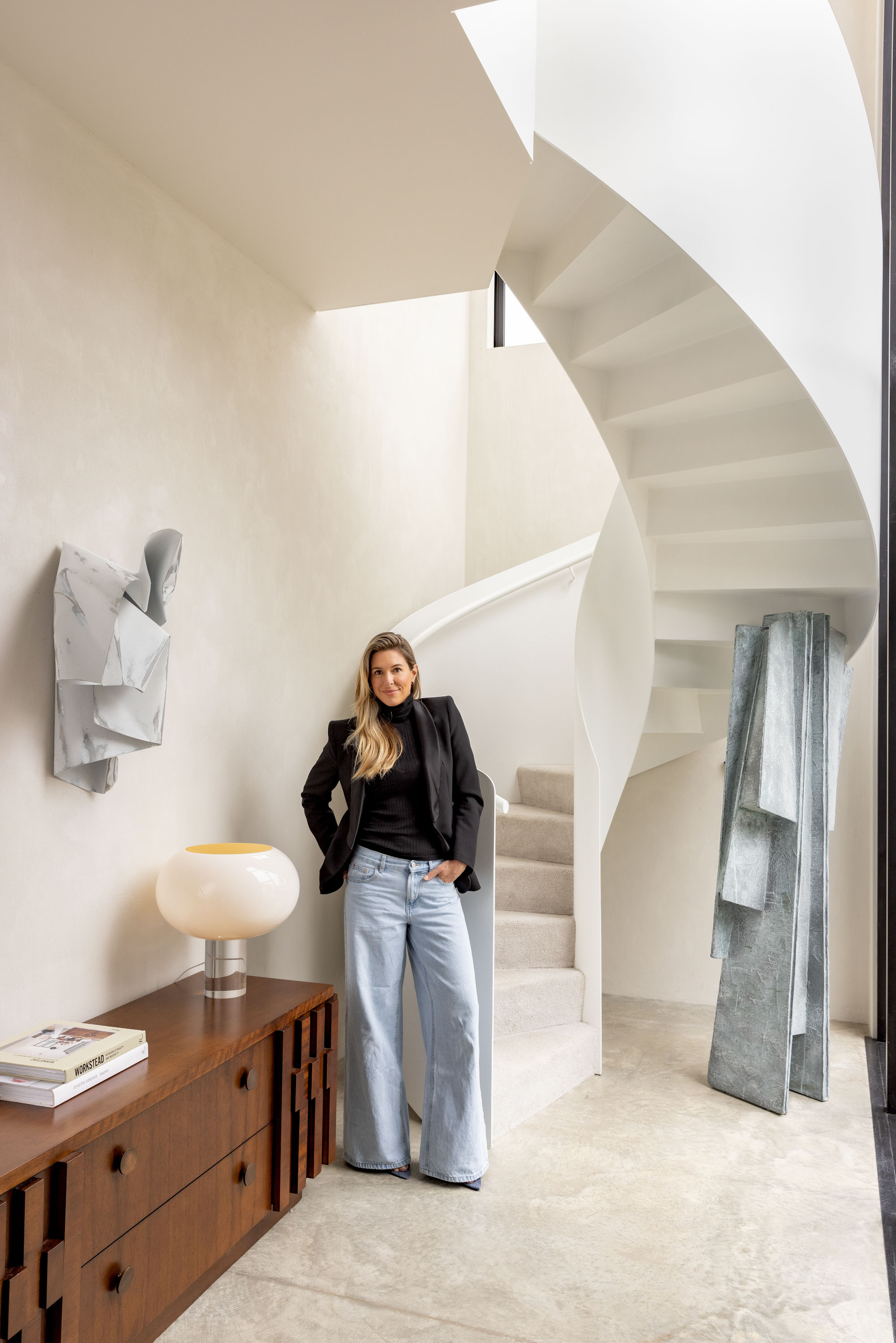 The home's showstopping spiral staircase. The wall sculpture is 'Aluminium Folds' by Jodi Newnham; the papier mâché floor sculpture is by an unknown artist and was sourced from LA. Photo / Babiche Martens