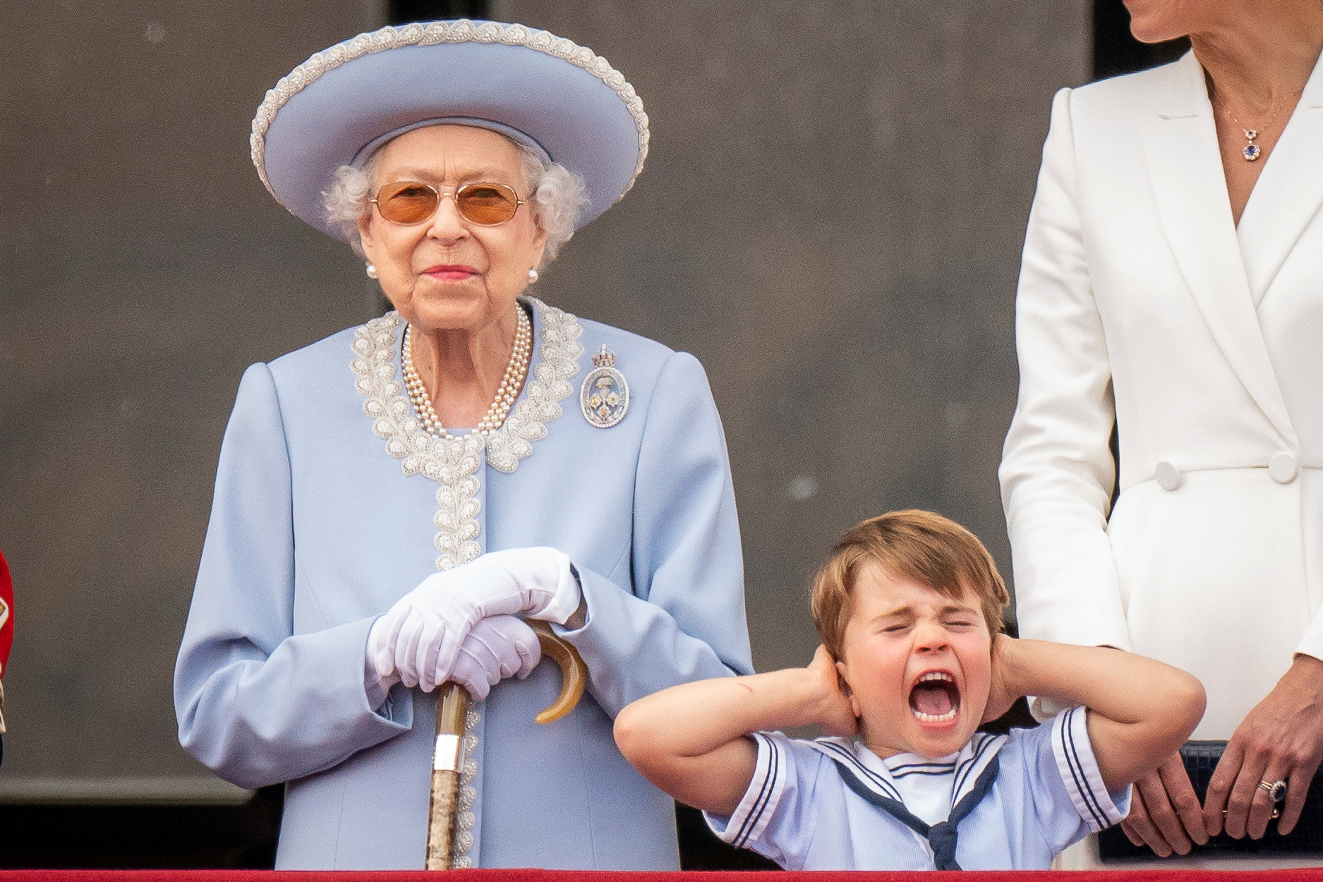 Queen Elizabeth II stands as Prince Louis covers his ears on the balcony of Buckingham Palace after the Trooping the Colour ceremony at Horse Guards Parade, central London. Photo / AP