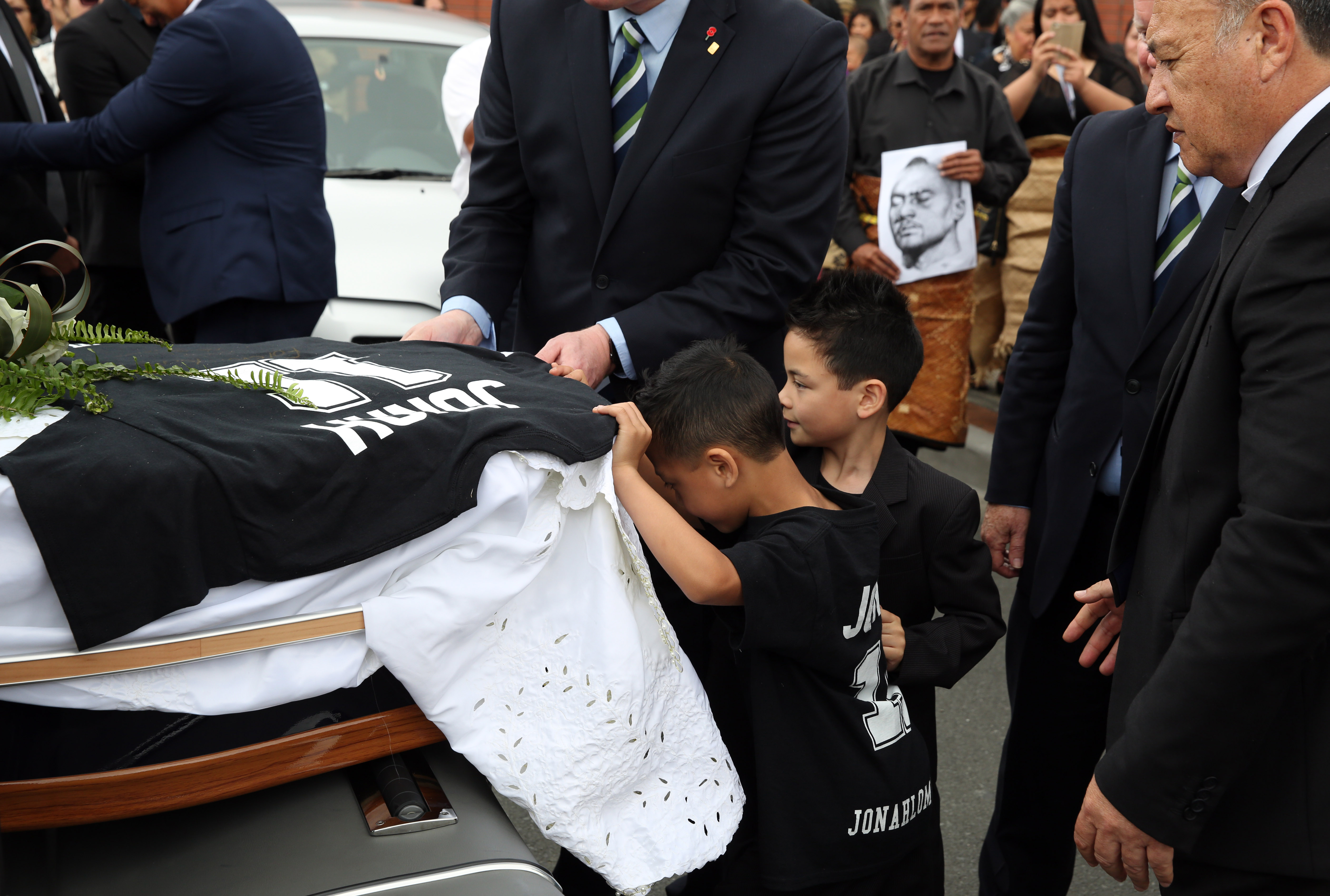 Brayley and Dhyreille help load their father's casket at his funeral. Photo / Getty Images
