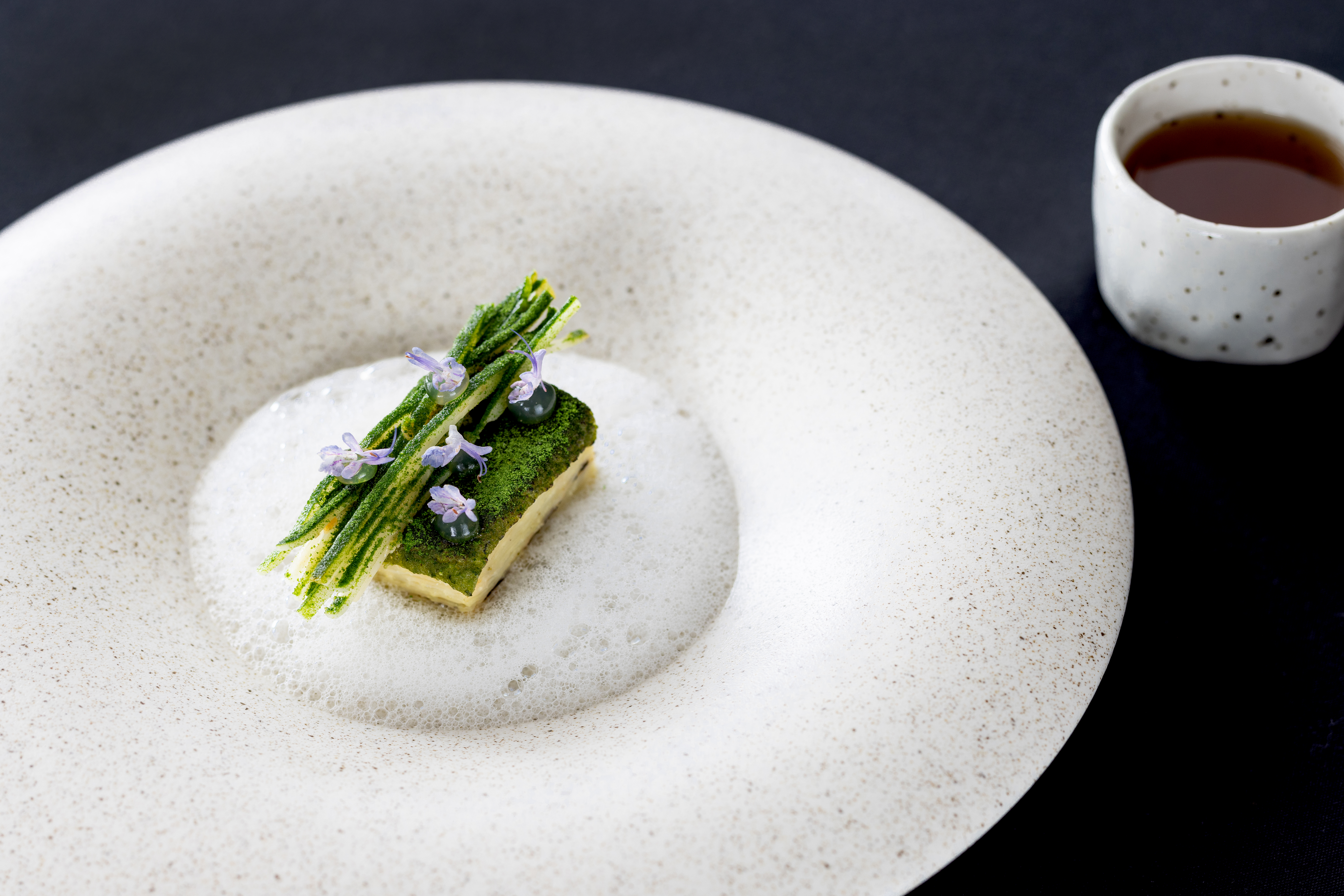Celeriac “terrine” with watercress vinaigrette, pine nut bubbles, fermented celeriac and chicken and anise tea (served on the side). Photo / Babiche Martens