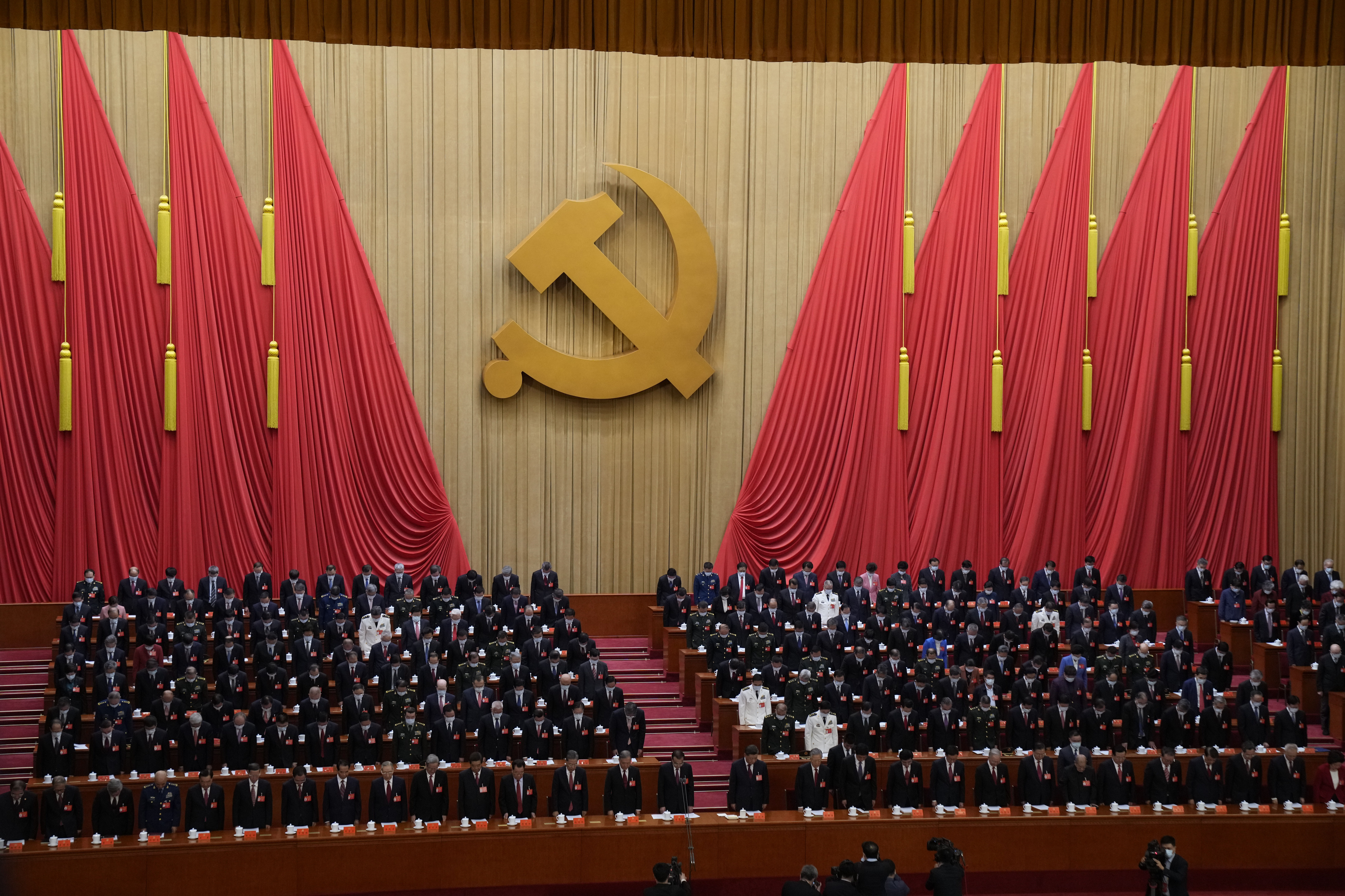 Attendees bow their heads to observe a moment of silence for fallen comrades during the opening ceremony of the 20th National Congress of China. Photo / Mark Schiefelbein, AP