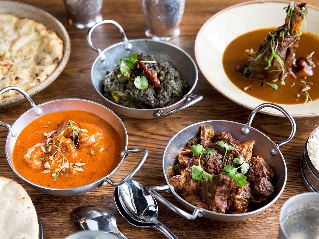 Clockwise from left, 1947 Eatery's butter chicken, saag paneer, lamb shank and dry goat curry. Picture / Babiche Martens