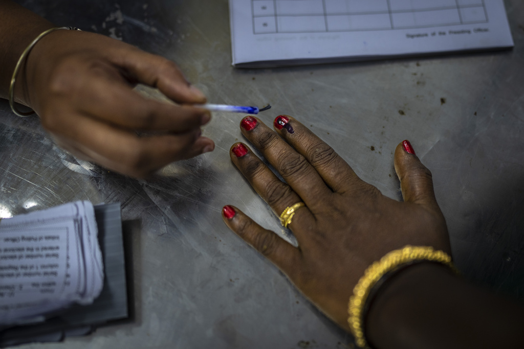 A polling official puts indelible ink mark on the index finger of a woman as she arrives to vote during the first round of voting of India’s national election in Chennai, southern Tamil Nadu state on April 19. Photo / AP