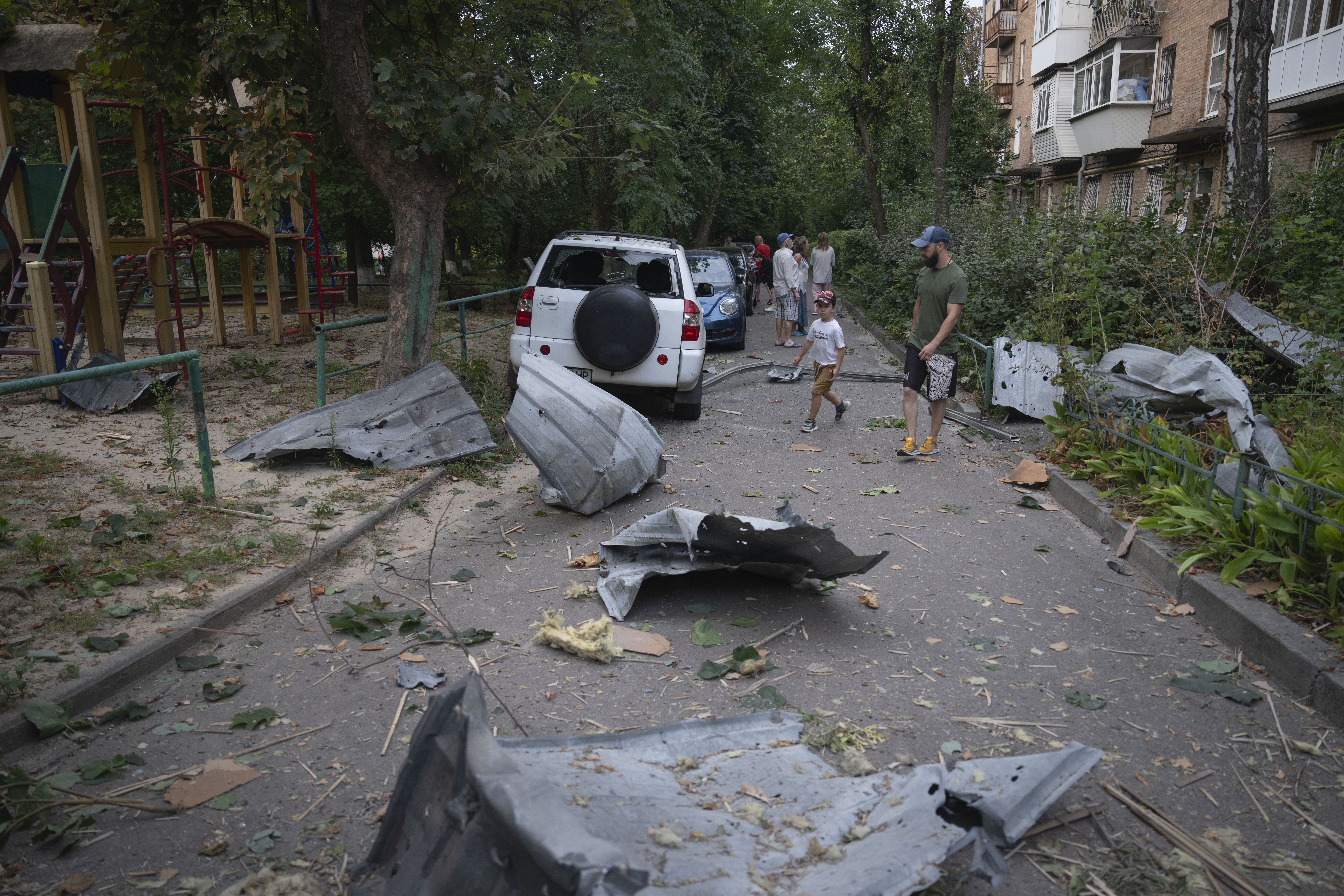 Local residents pass by debris in Kyiv, Ukraine, Wednesday, Aug. 30, 2023, that fell down from their damaged house after a Russian massive rocket attack. Photo / AP