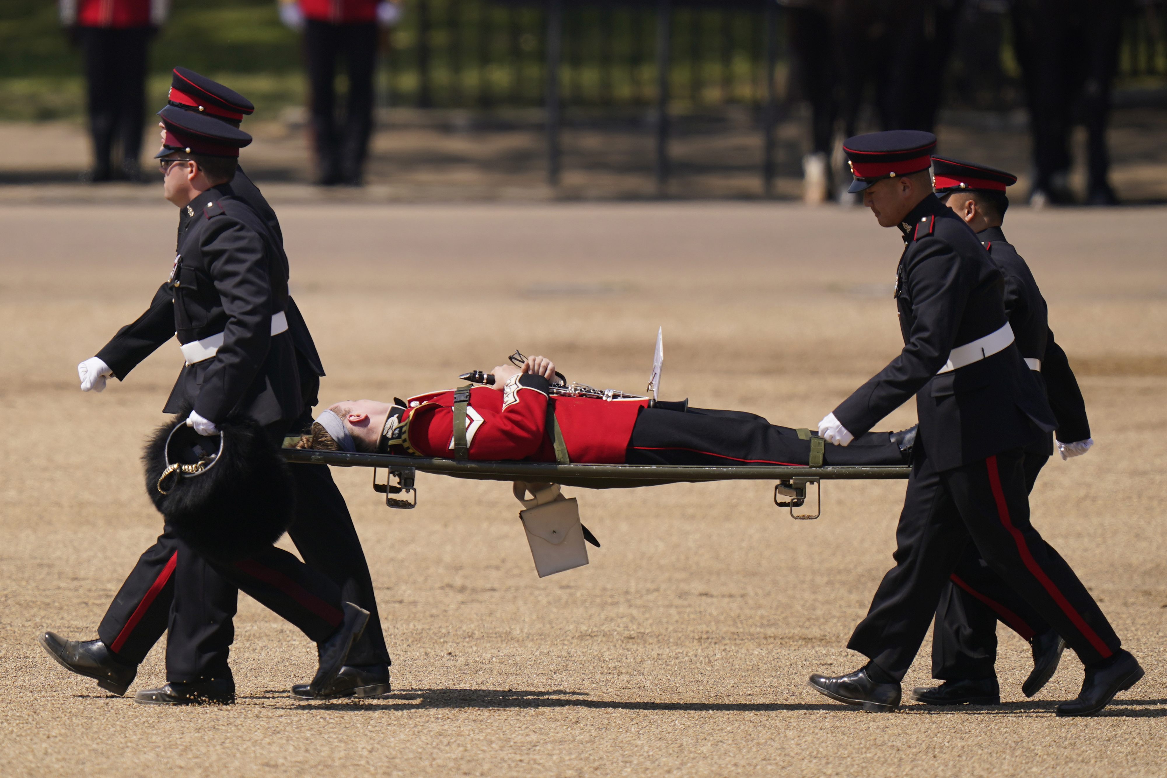 A trombone player of the military band is carried out on a stretcher after a faint during the Colonel's Review, the final rehearsal of the Trooping the Colour, the King's annual birthday parade, at Horse Guards Parade in London. Photo / AP