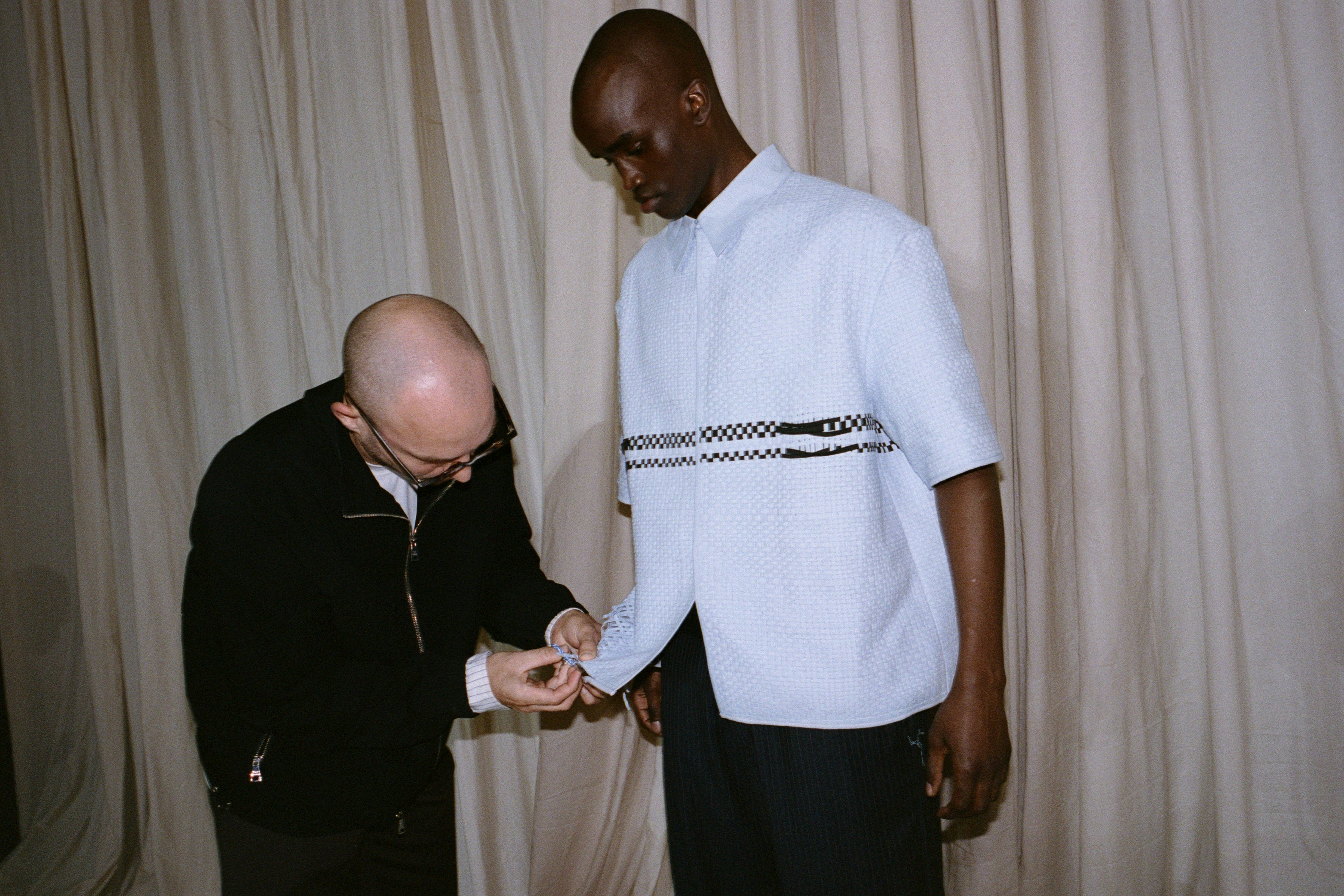 Wynn Crawshaw snips at a shirt in preparation for the runway. Photo / Rob Tennent
