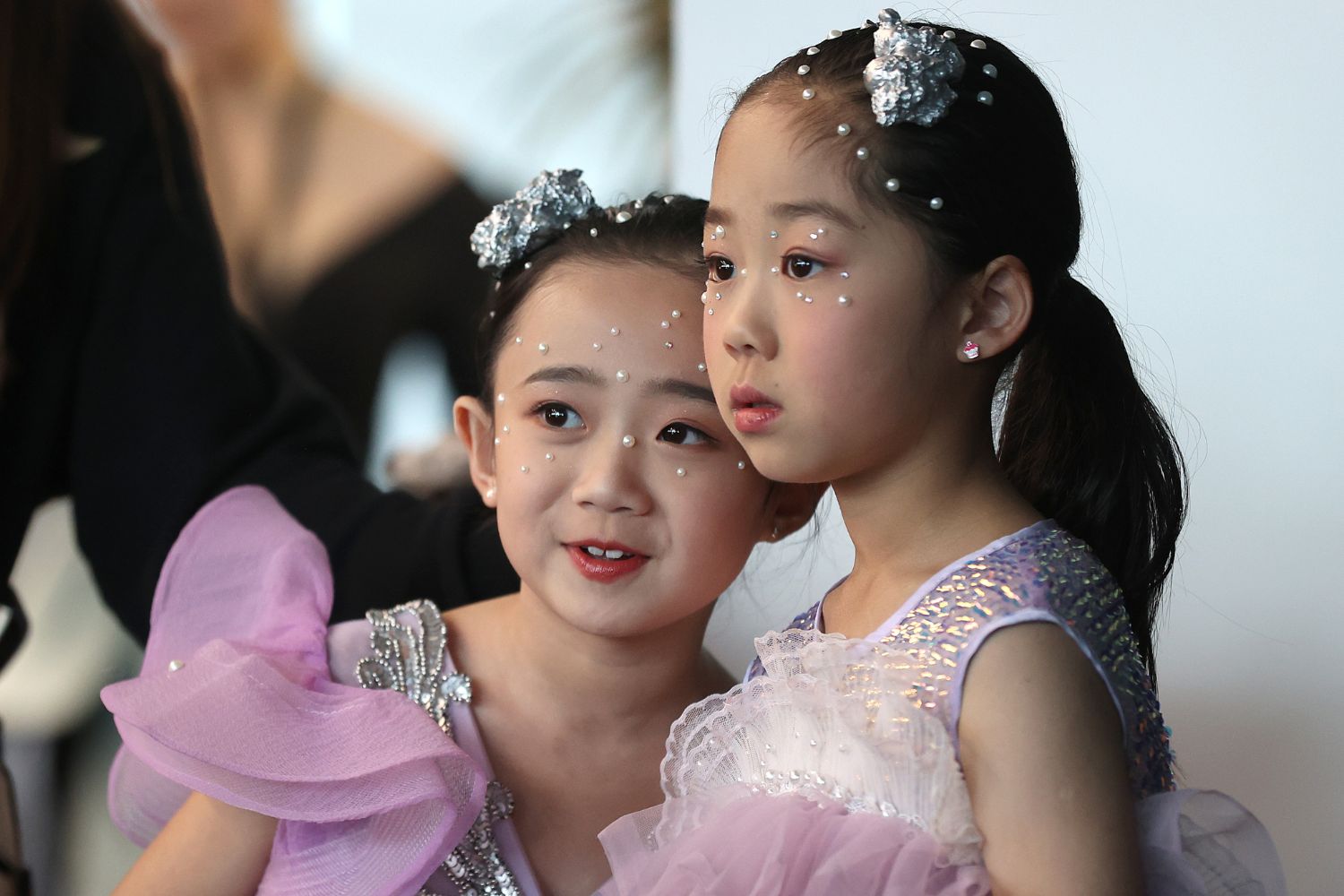 Two (very cute) mini models await their turn on the runway after having delicate pearls applied individually to their faces. Photo / Getty Images