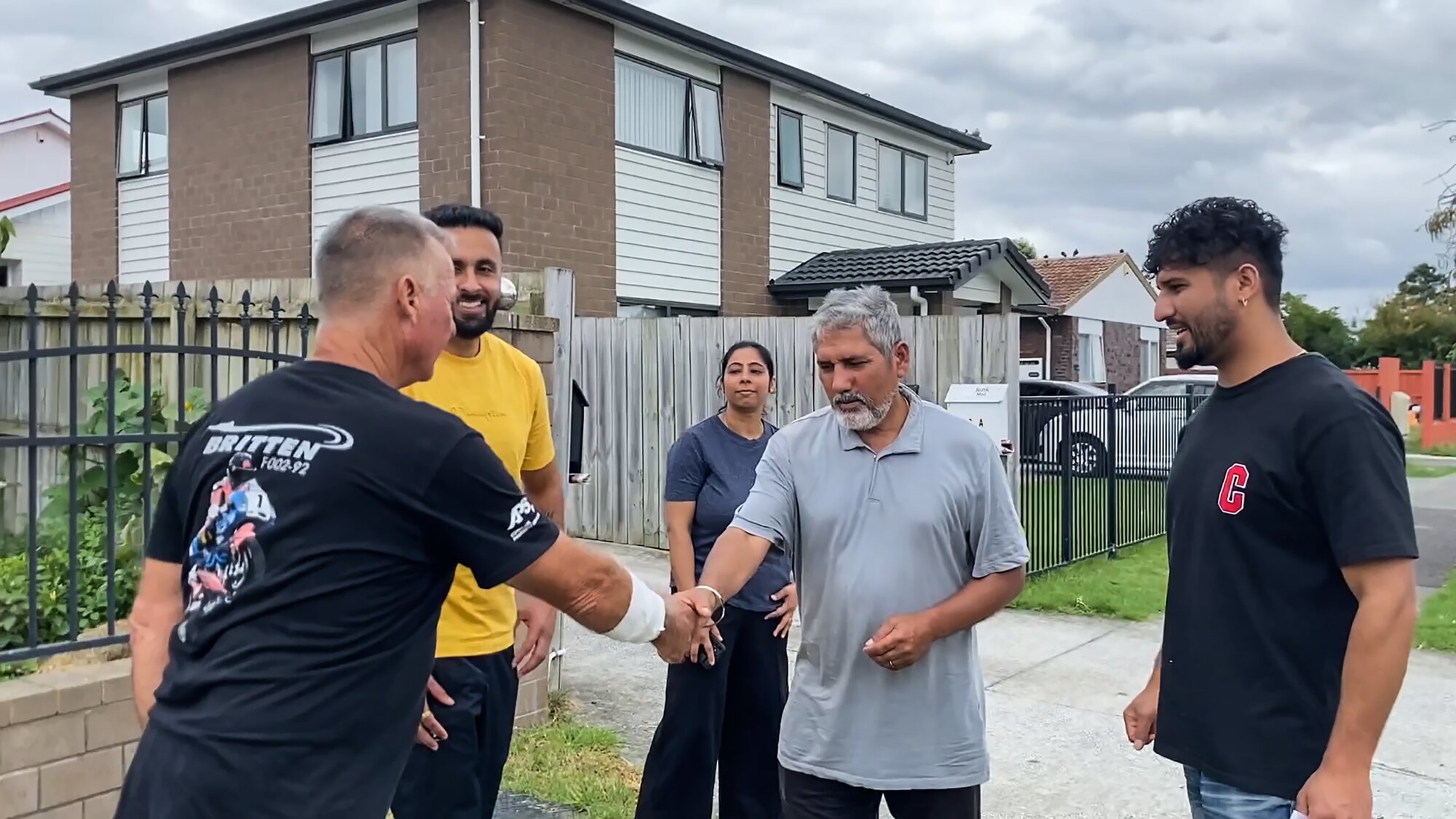 Paul Dore shakes hands with a man he saved from a dog attack. The man's son, Davinder Singh (right), said Dore was a 