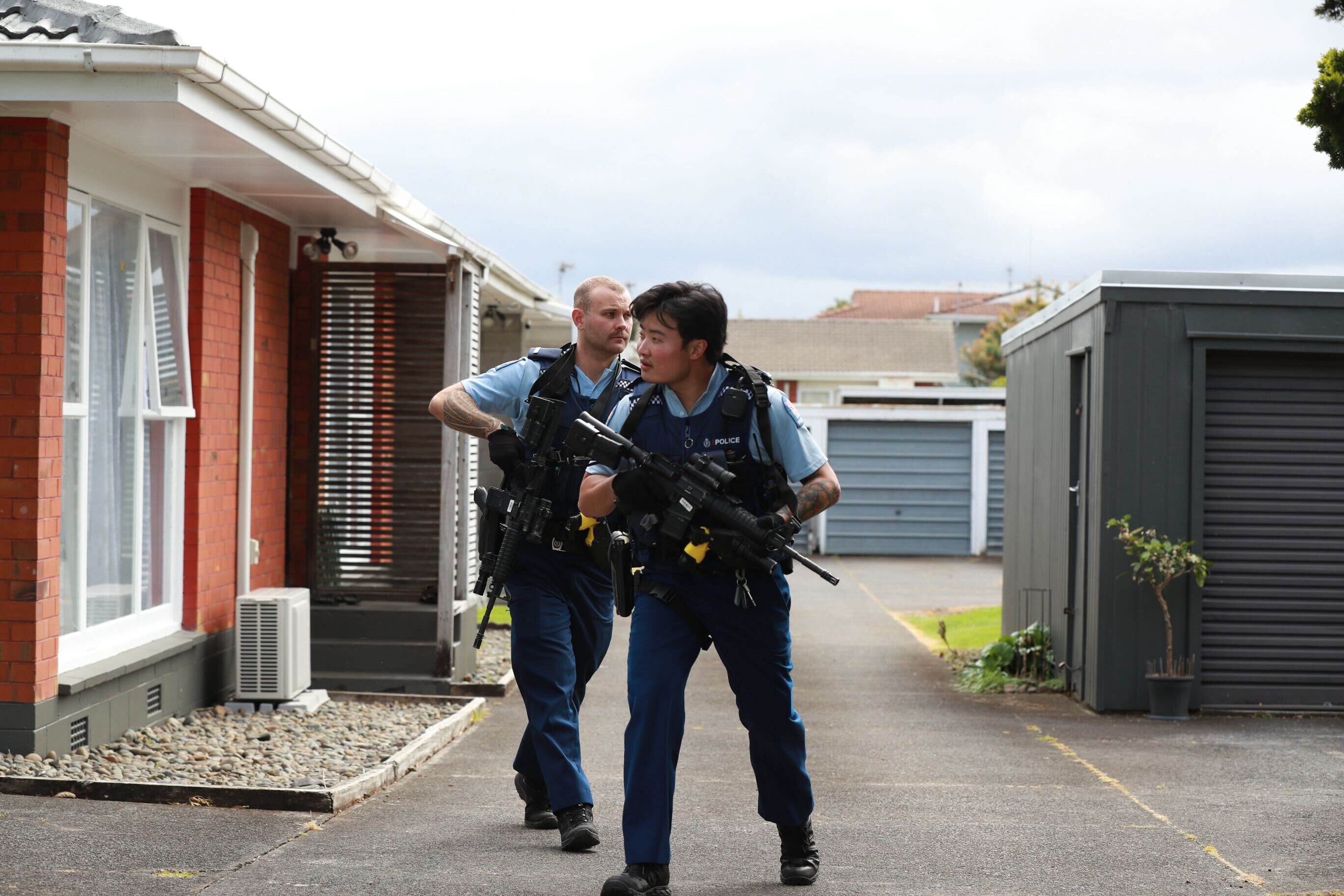 Armed police search a property on Victoria St, Onehunga, following an alleged stabbing on a bus nearby. Photo / Hayden Woodward