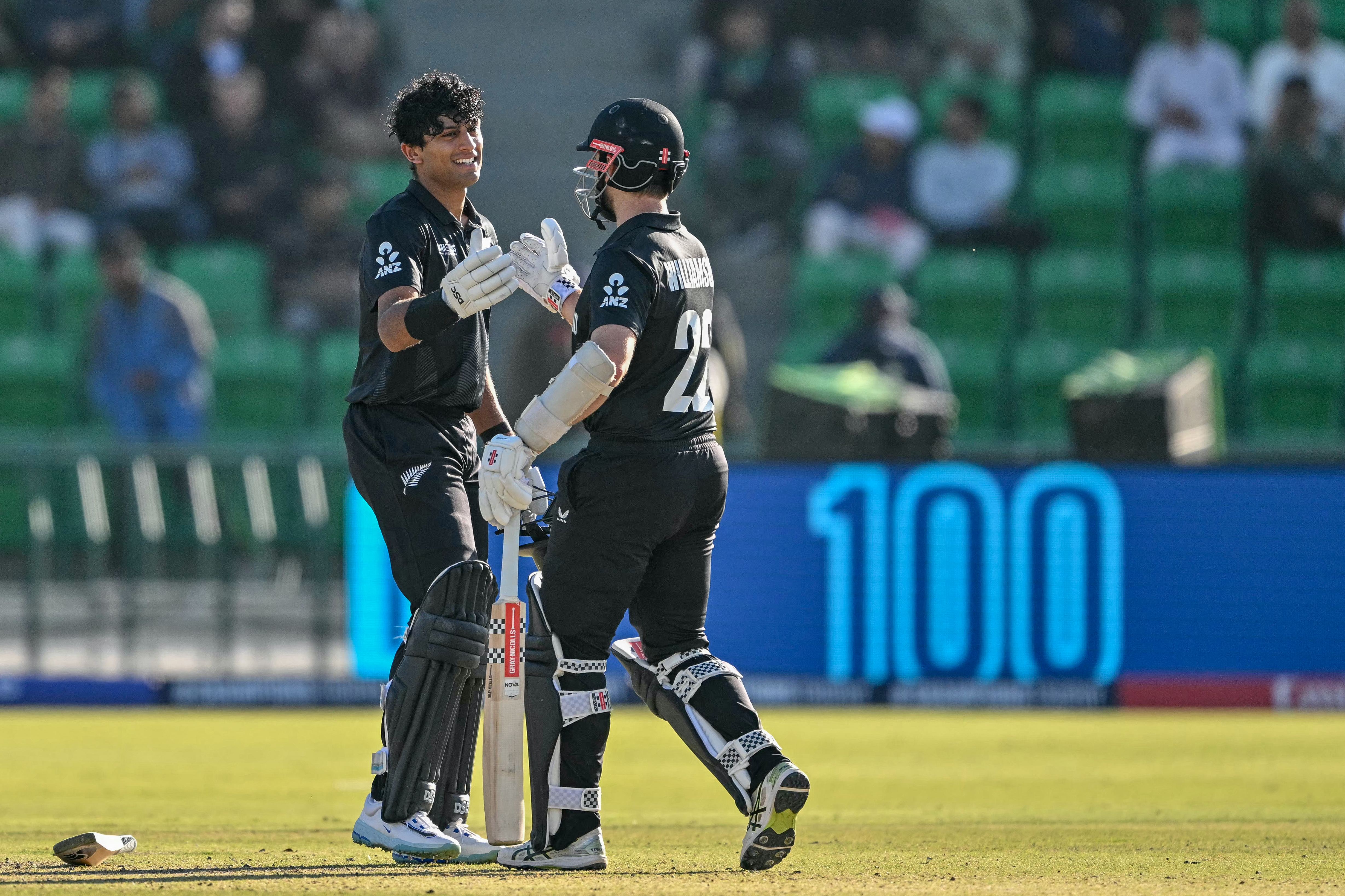 Rachin Ravindra celebrates a century against South Africa with Kane Williamson. Photo / AFP