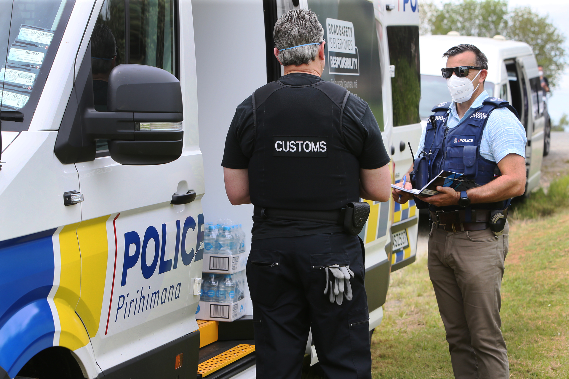 A Customs investigator speaks to Detective Senior Sergeant Kevan Verry of the Organised Crime unit at Takahiwai during the first phase of Operation Freya. Photo / Tania Whyte
