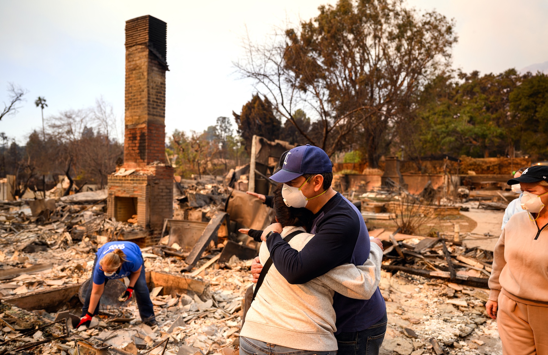 Family members embrace while viewing their burned home during the Eaton fire in the Altadena area of Los Angeles county, California. Photo / AFP