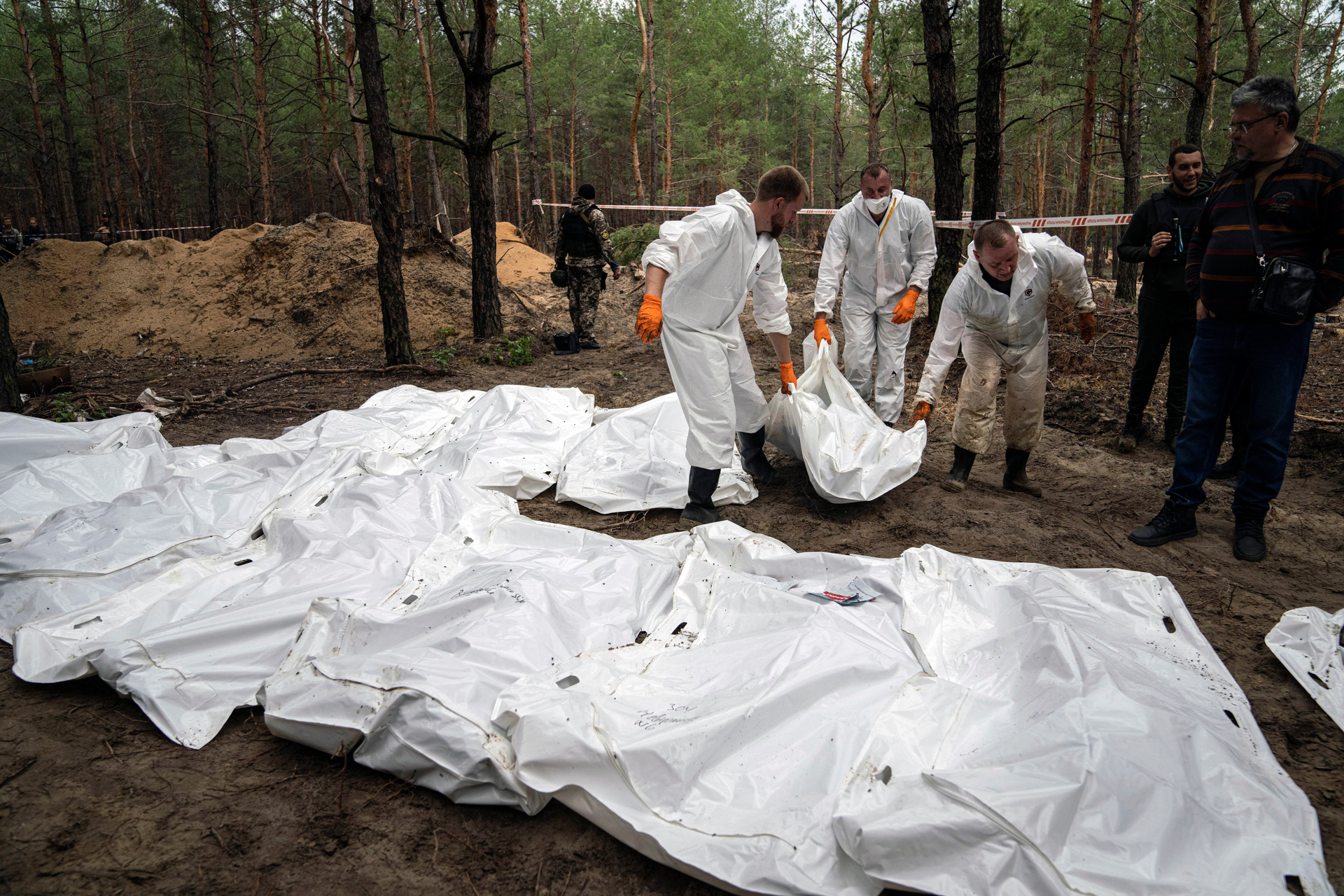 Experts work during the exhumation of bodies in the recently retaken area of Izium, Ukraine on Friday. Ukrainian authorities discovered a mass burial site near the recaptured city of Izium. Photo / AP