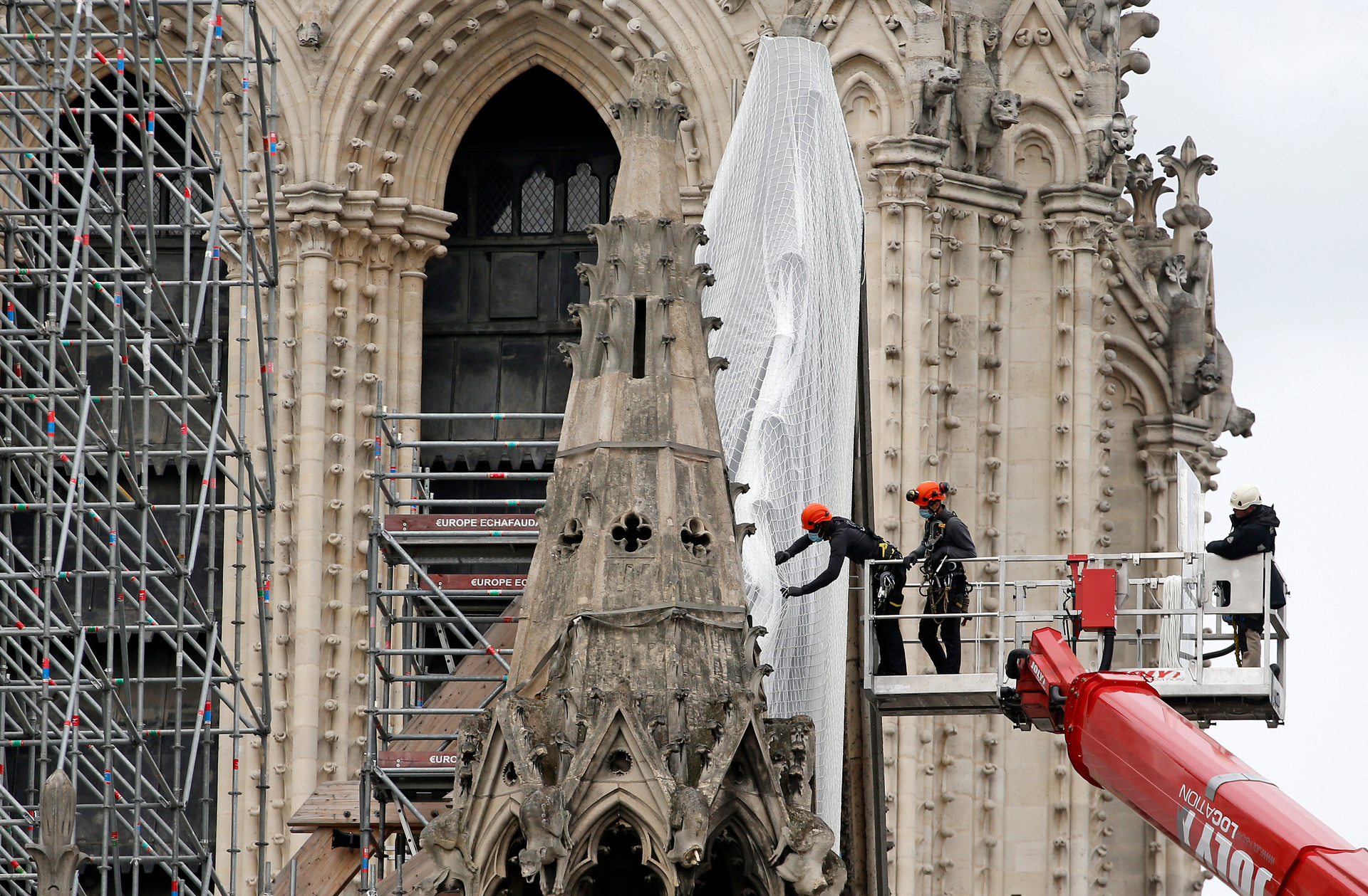 Professional mountain climbers wearing protective face masks help dismantle scaffolding around the Notre Dame Cathedral over a year after the 2019 fire. Photo / Getty Images
