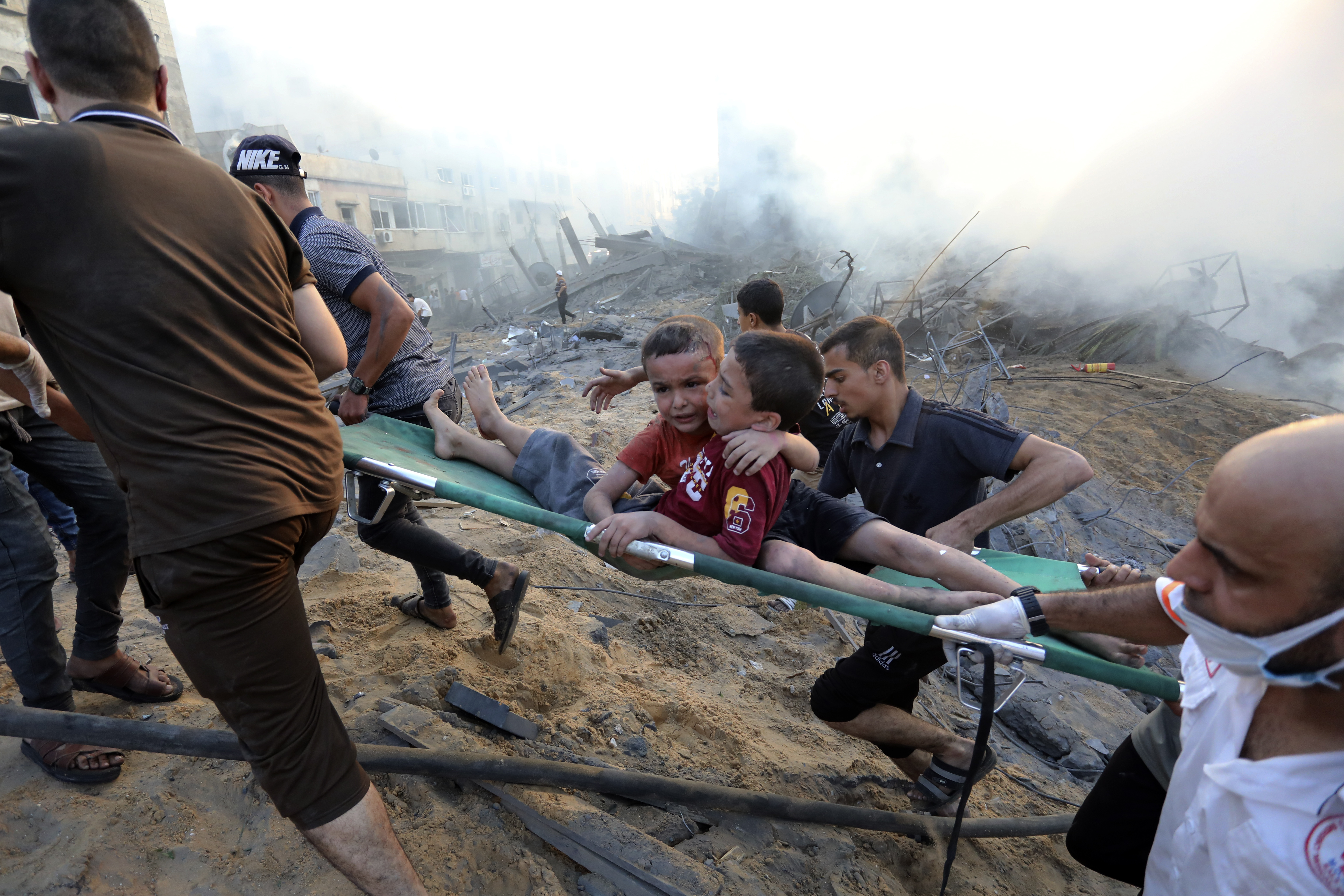 Palestinians evacuate two wounded boys out of the destruction following Israeli airstrikes on Gaza City. Photo / AP