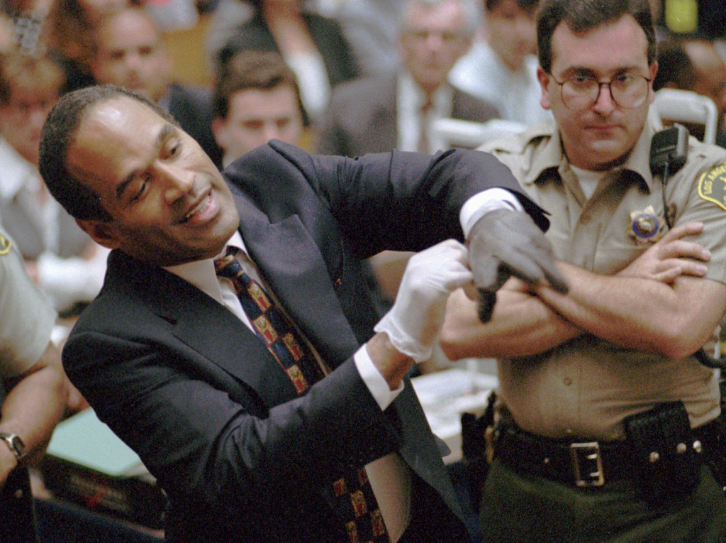 In this June 15, 1995 file photo, OJ Simpson grimaces as he tries on one of the leather gloves prosecutors say he wore the night his ex-wife Nicole Brown Simpson and Ron Goldman were murdered. Photo / AP