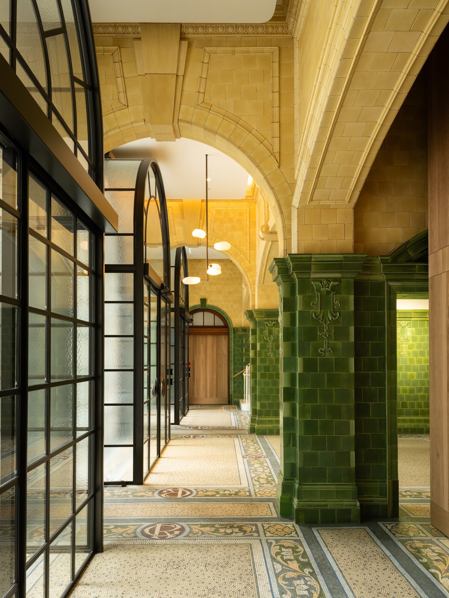 New steel-framed entry doors and heritage tiles and mosaics are a feature of the refurbished lobby. Photo / Samuel Hartnett