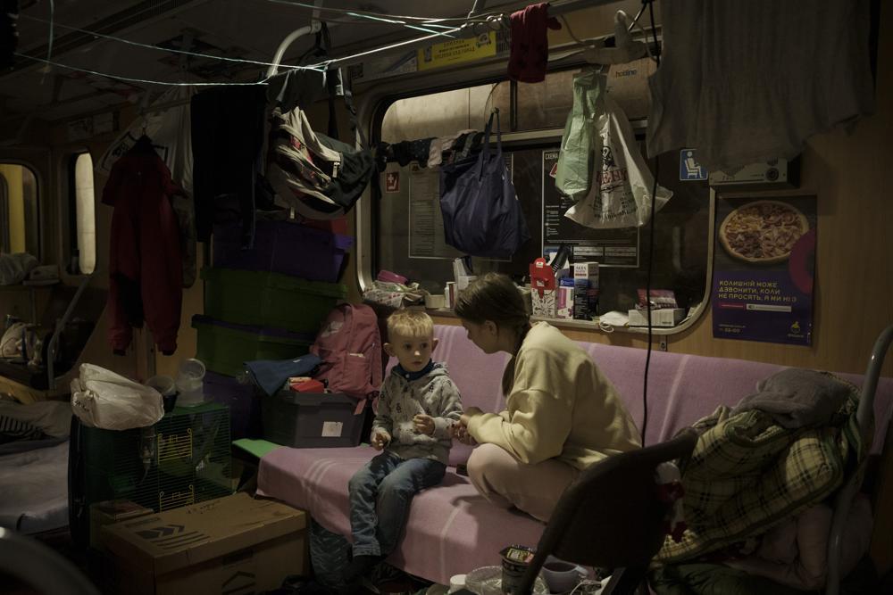 People sit inside a subway car, parked in a station being used as a bomb shelter, as Russian attacks continue in Kharkiv, Ukraine on March 25. Photo / AP