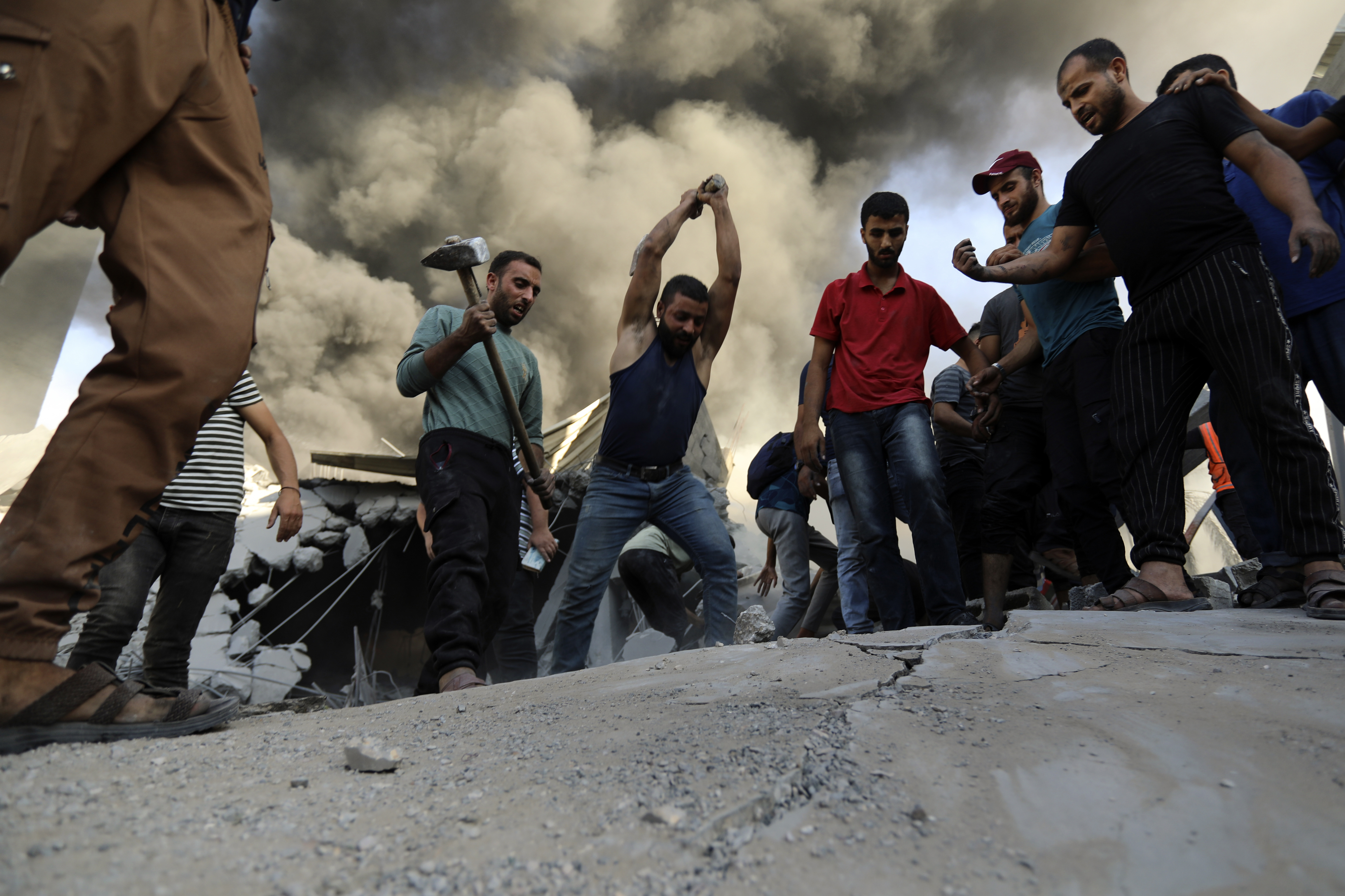 Palestinians strike concrete while looking for survivors under the rubble of a destroyed house following an Israeli airstrike in Gaza City. Photo / AP