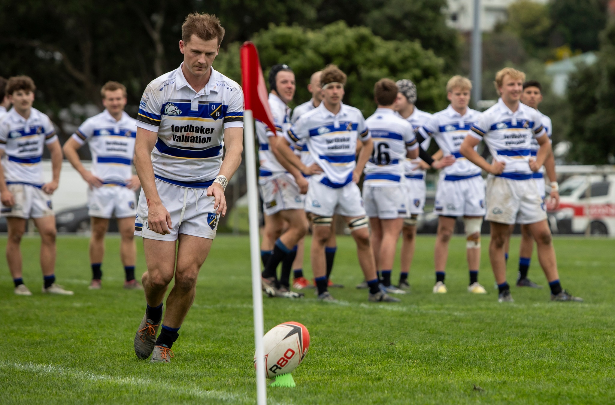Jarred Percival lines up a shot at goal while the Light Bears prepare to celebrate another win. Photo / Tane Nathan, Club Rugby