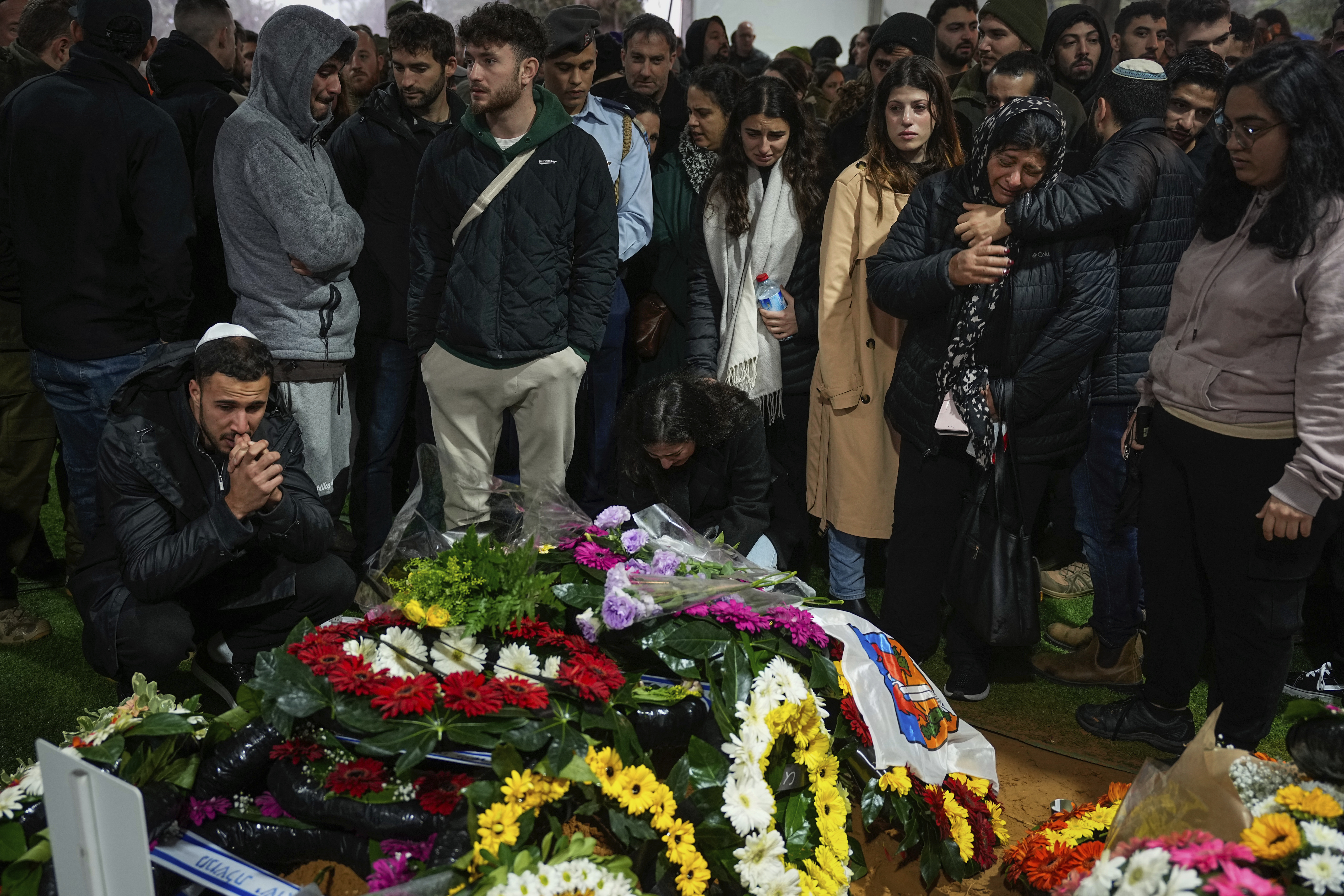 Family and friends of Israeli reservist Hadar Kapeluk mourn over his grave during his funeral at Mt Herzl military cemetery in Jerusalem. Photo / AP