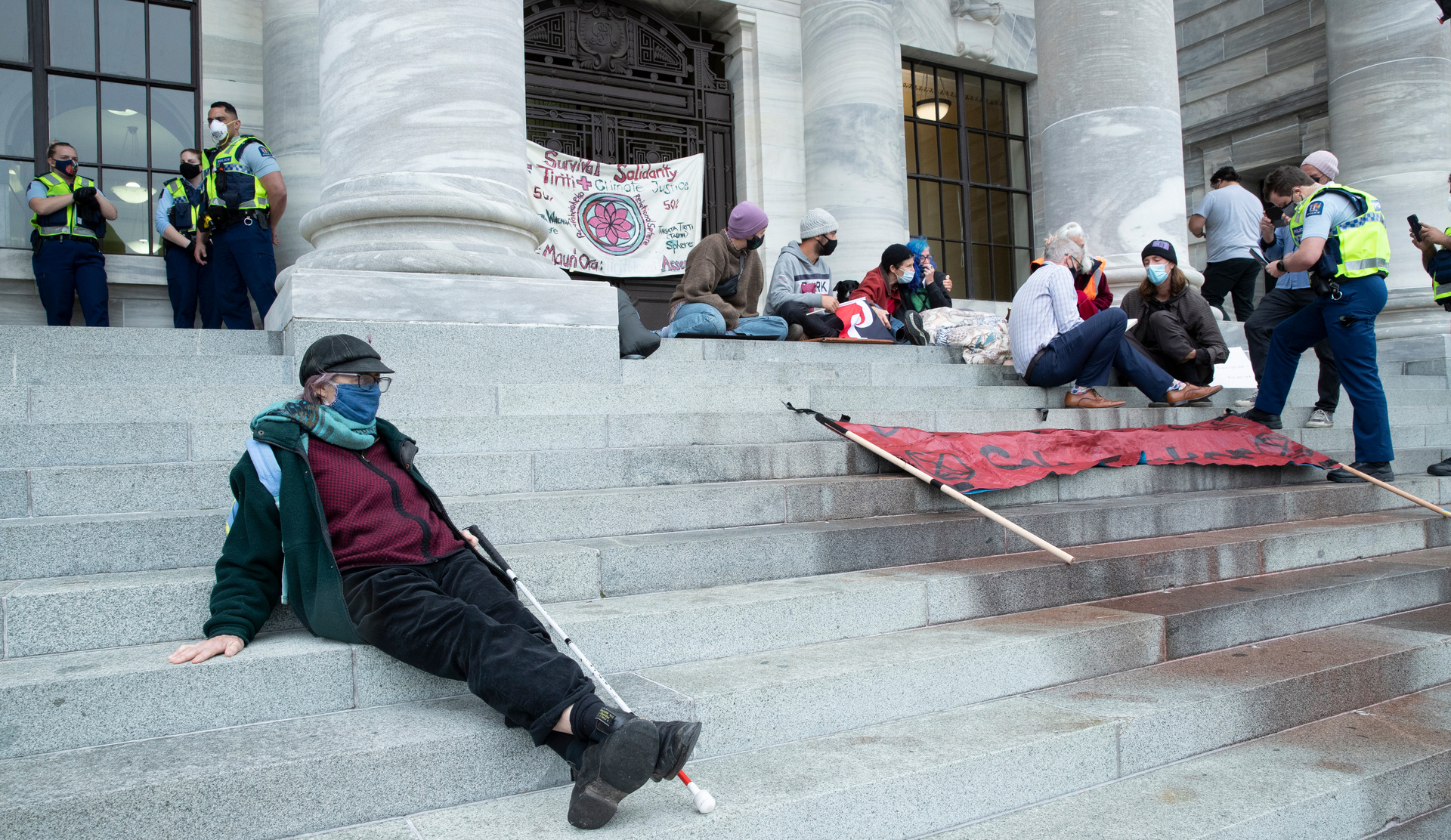 Police and security staff get details from protesters who glued themselves to Parliament steps. Photo / Mark Mitchell 