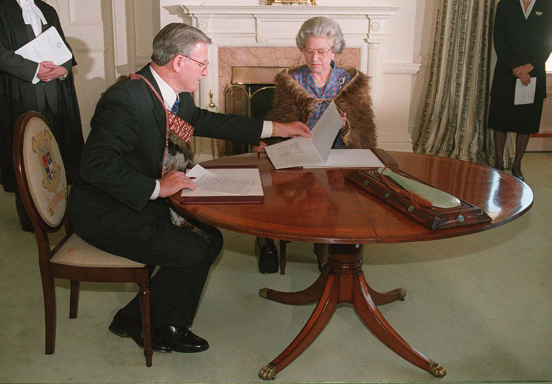 New Zealand Prime Minister Jim Bolger and Queen Elizabeth sign the historic Tainui land settlement deed at Government House in Wellington. Photo / Getty