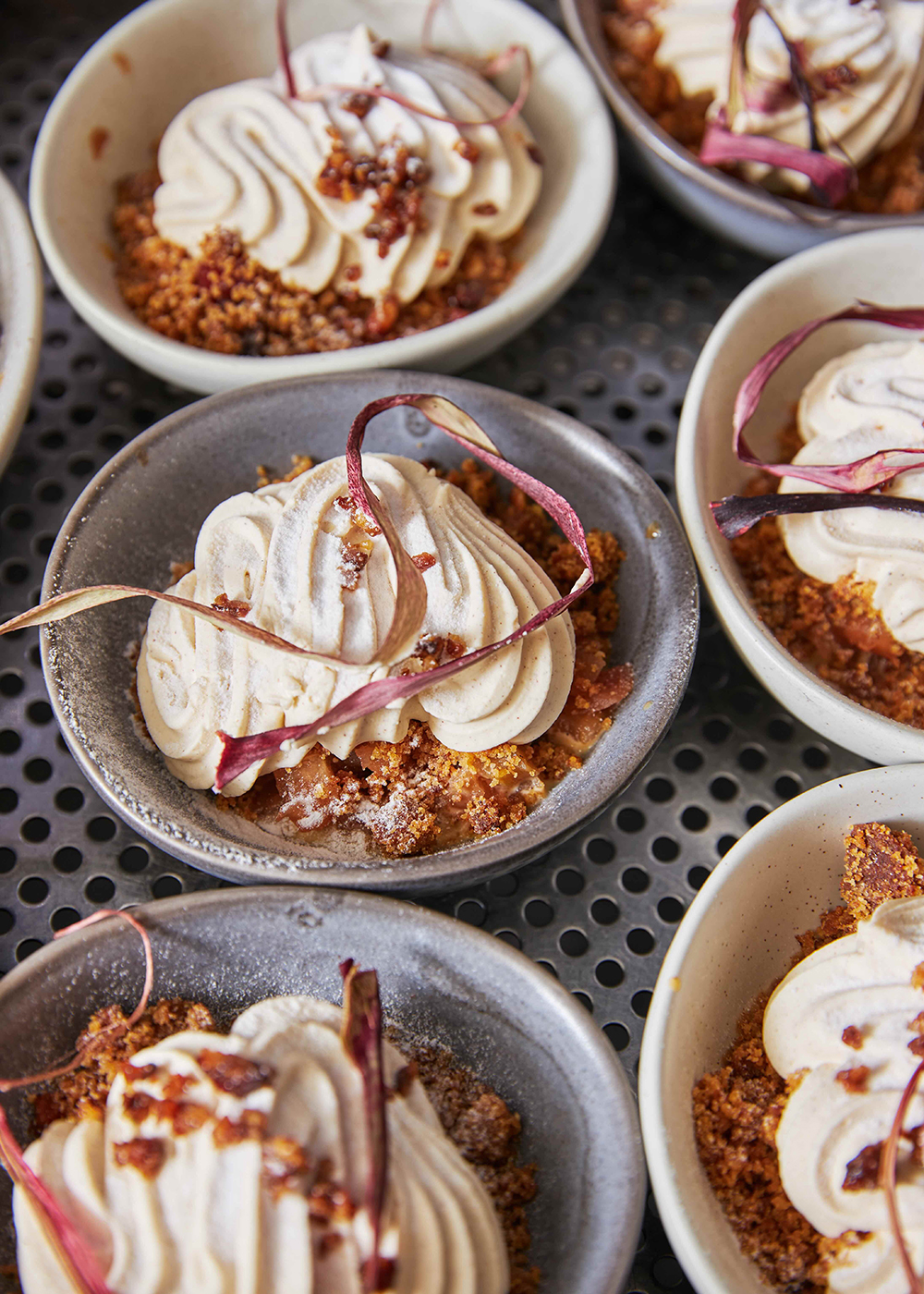 Single dessert servings, topped with velvety creams and dried fruit ribbons.