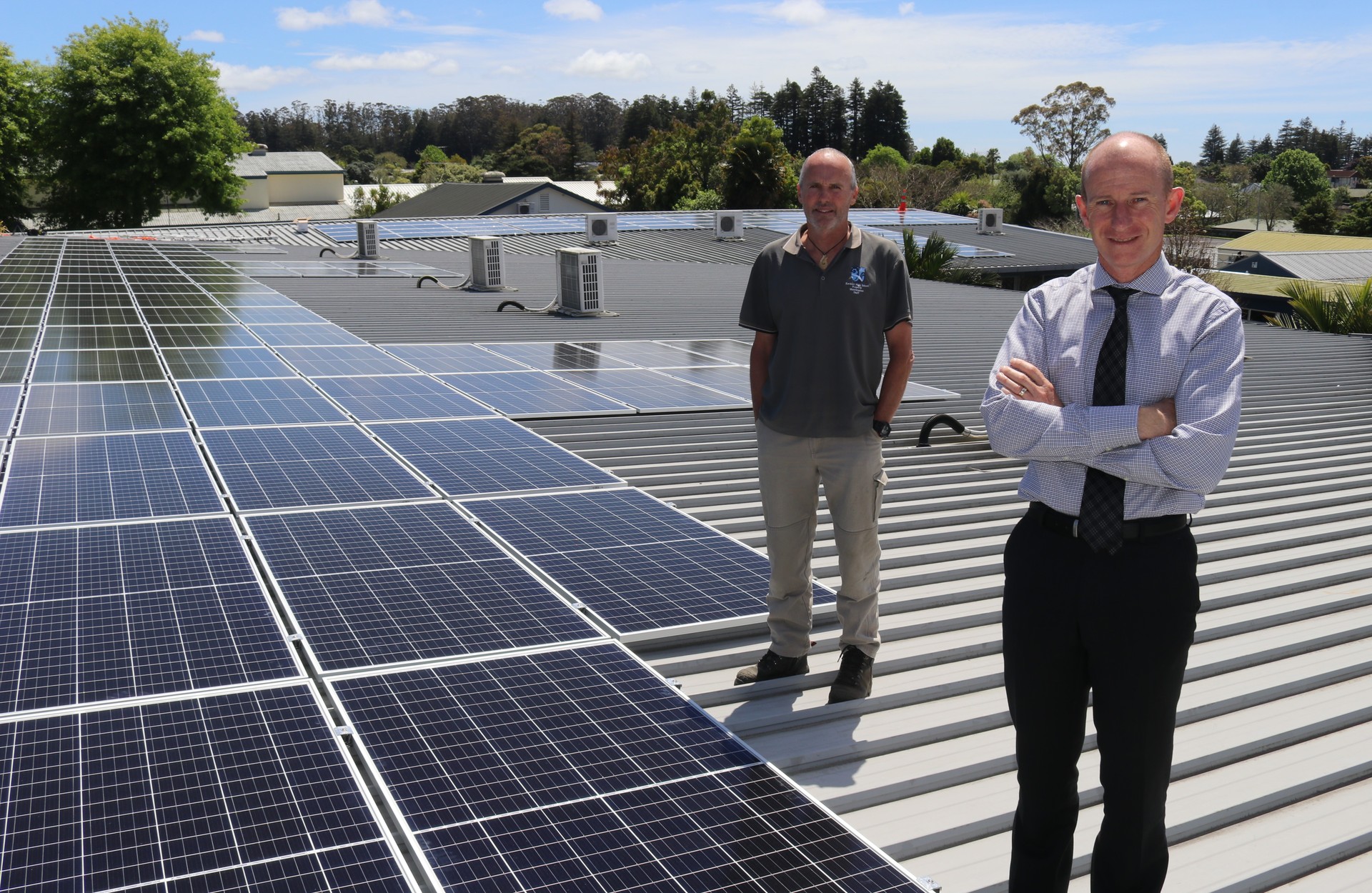 Kerikeri High School property manager Richard Pilling (left) and associate principal Mike Clent atop the Business, Enterprise and Social Sciences building where a 174kW solar power system is slashing the school’s power bills. Photo / Peter de Graaf
