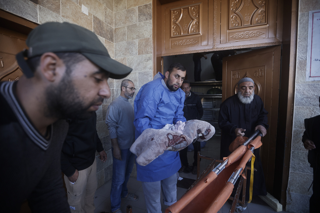 A morgue worker carries out the body of a Palestinian child killed in the Israeli bombardment of the Gaza Strip in Khan Younis, Saturday, January 6. Photo / AP