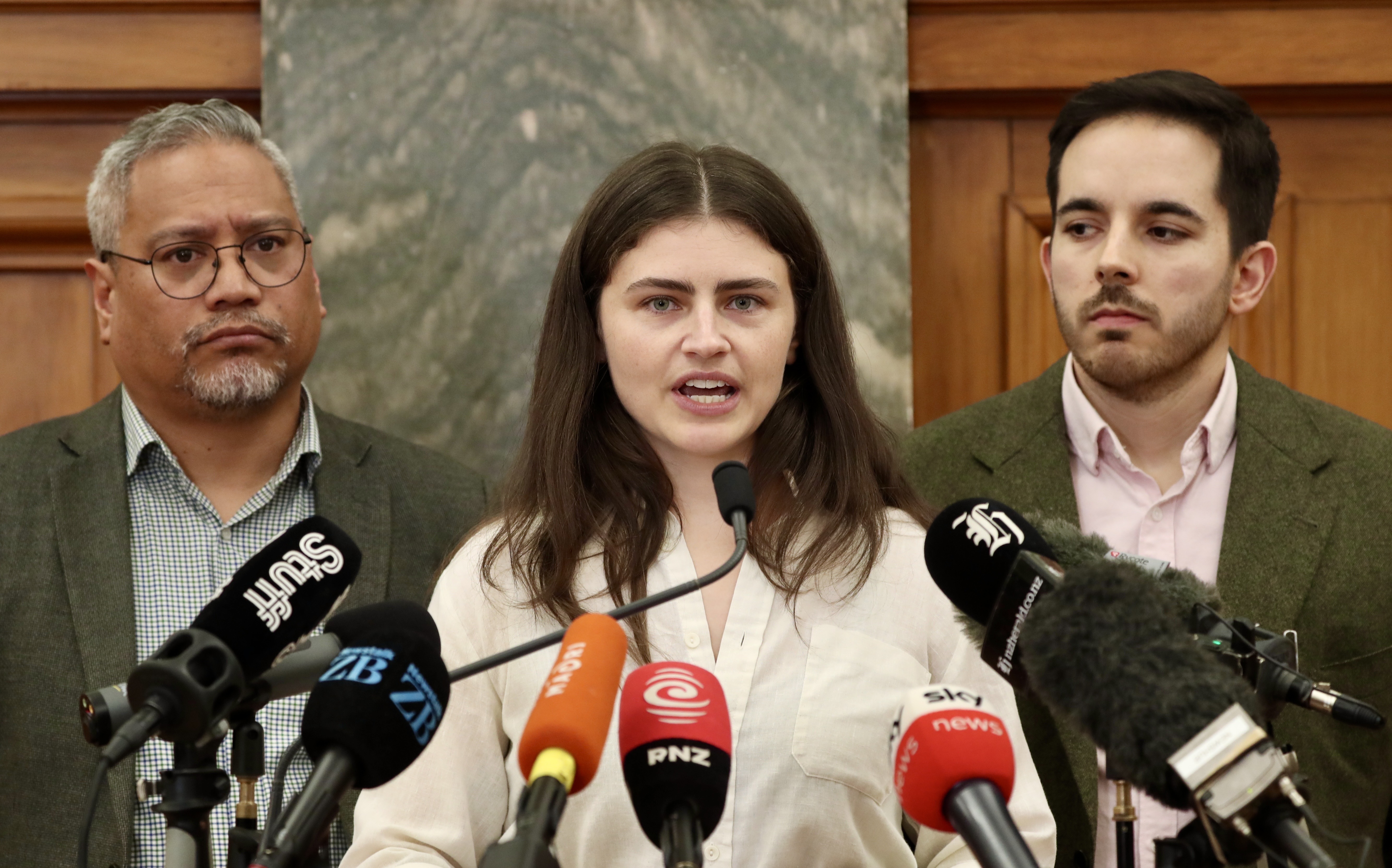 Greens co-leader Chlöe Swarbrick (centre), joined by colleagues Ricardo Menendez March (right) and Teanau Tuiono, reveals rogue MP Darleen Tana has been told to resign. Photo / Mark Mitchell