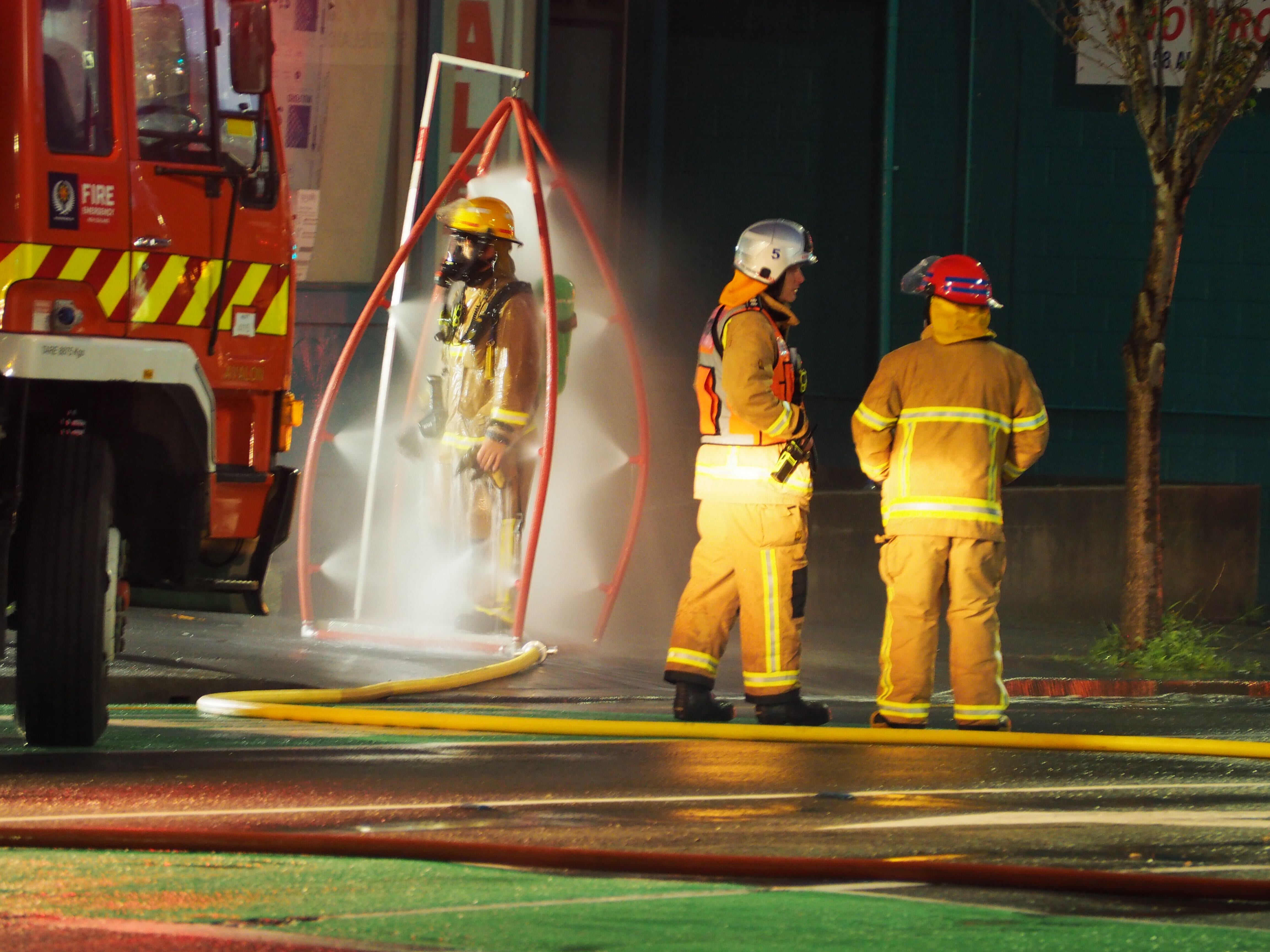 Firefighters are sprayed with chemicals after battling the blaze. Photo / Nick James
