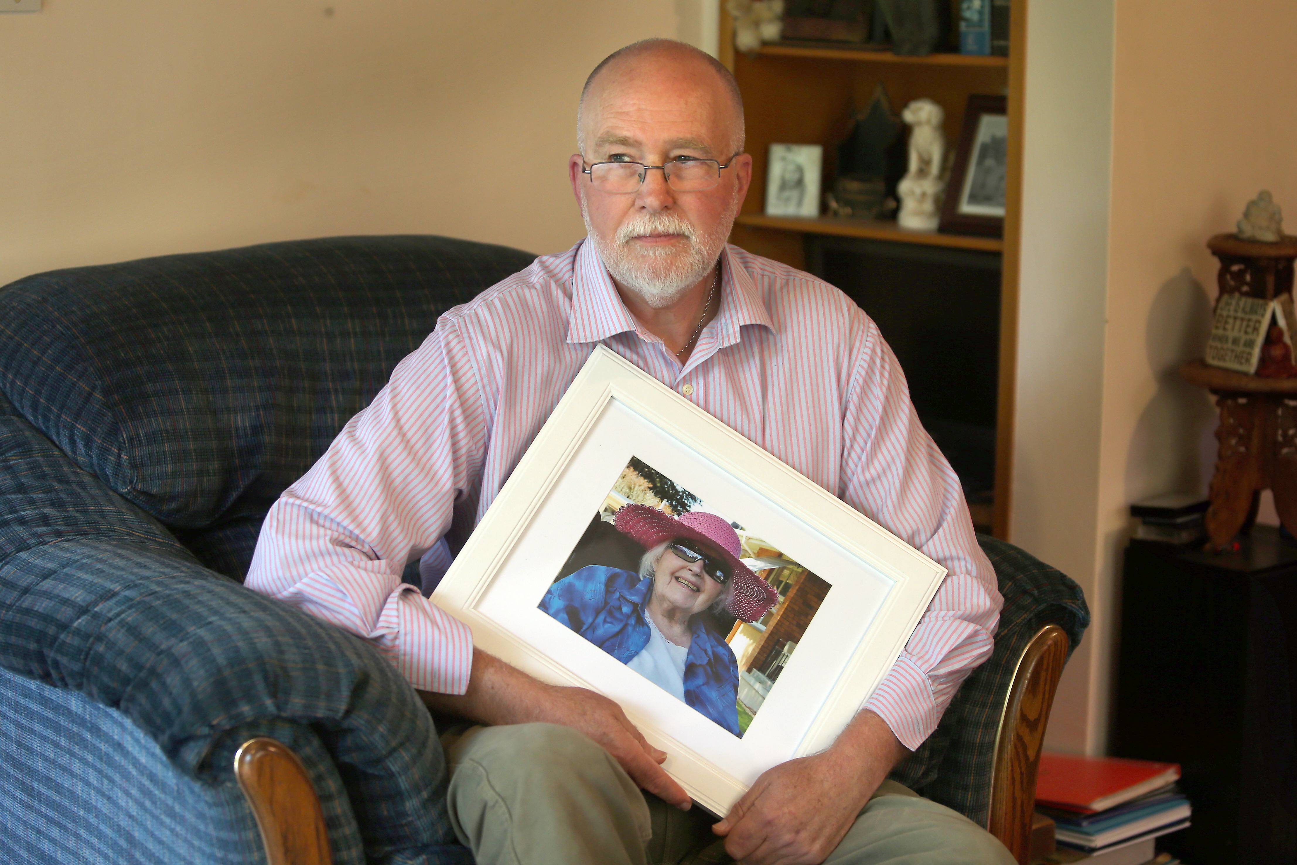 Robert Love holds a picture of his late mother, who suffered distress from failings in care during her time in a rest home. Photo / John Borren